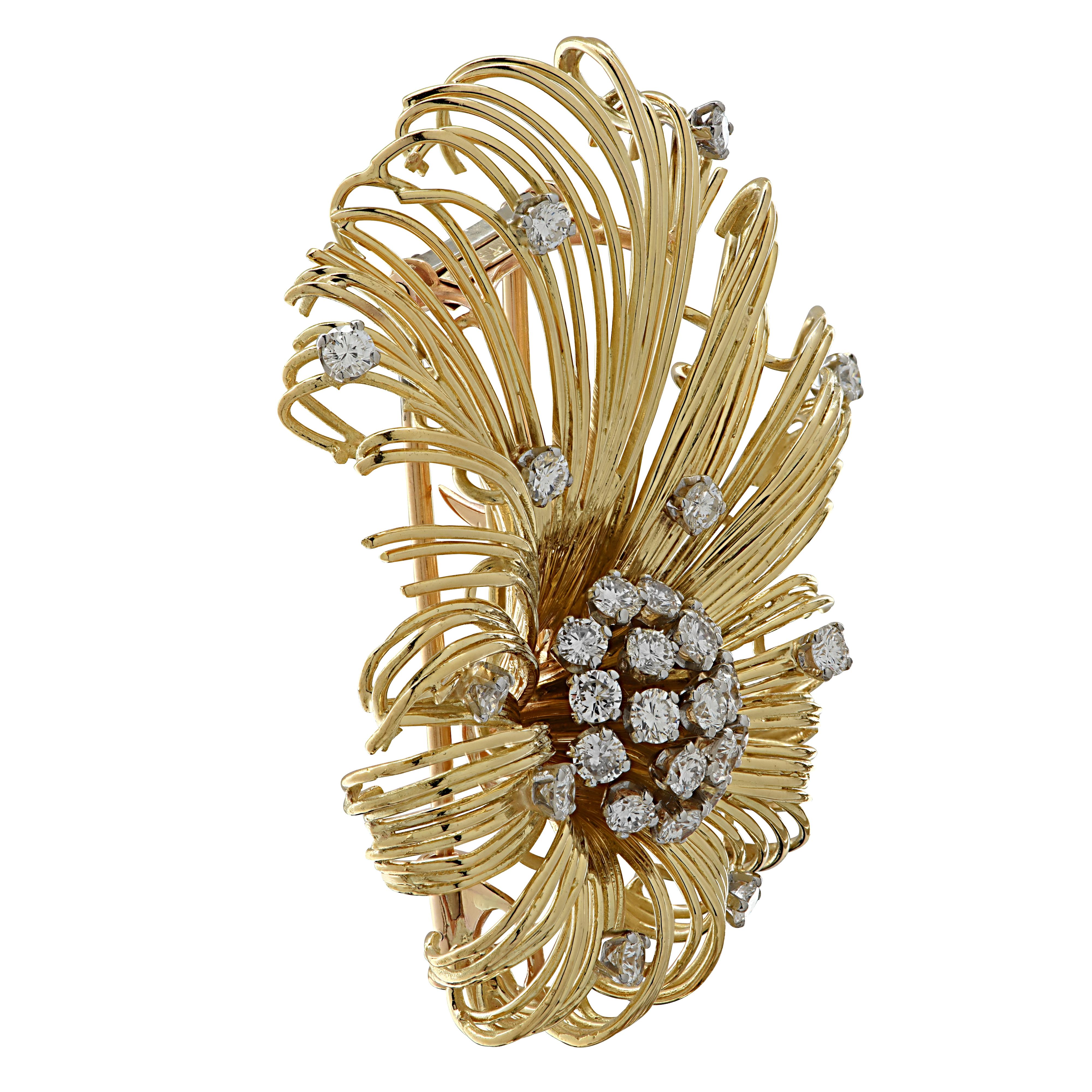 Striking Tiffany and Co. brooch pin, finely crafted in 18 karat yellow gold featuring 29 round brilliant cut diamonds weighing 2.5 carats total, F color VVS-VS clarity. Delicate wisps of gold, sprinkled with diamonds, radiate from the center diamond