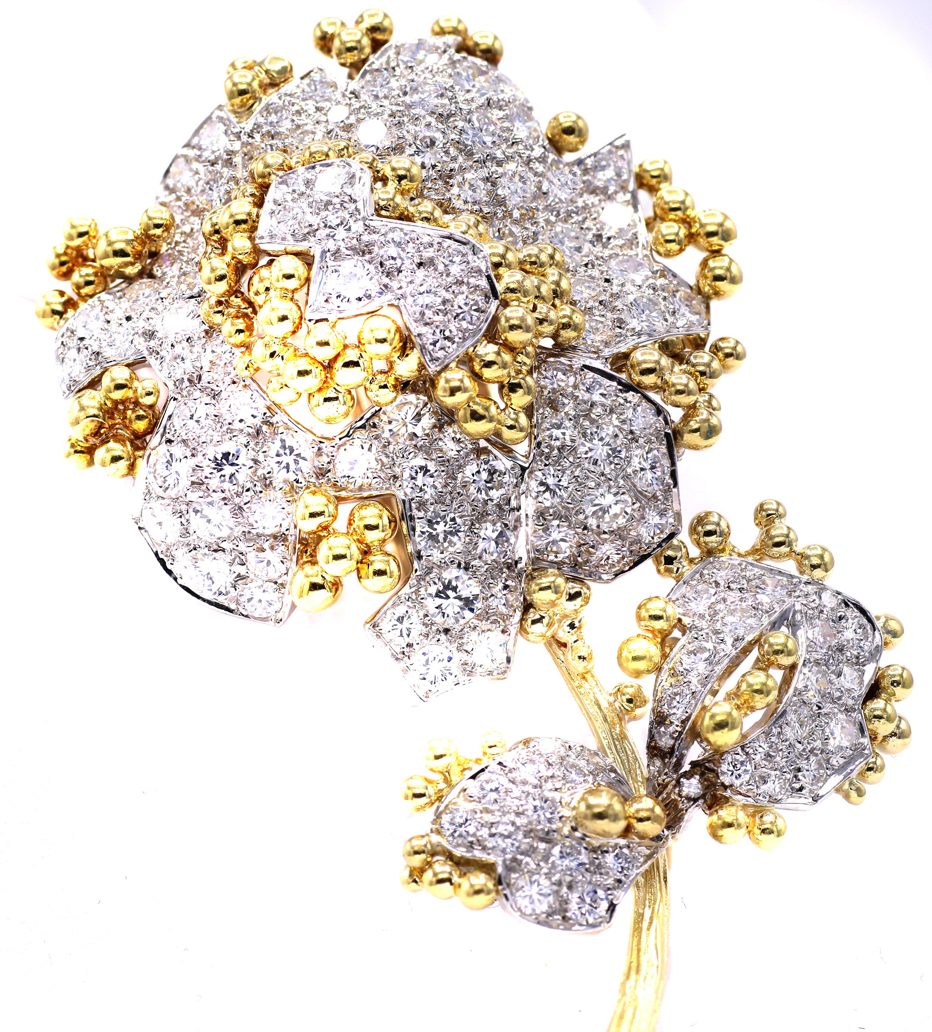 Magnifiquement conçue et fabriquée à la main, cette broche fleur des années 1980 représente de manière réaliste et tridimensionnelle chaque détail des pétales, de la tige et des feuilles. Méticuleusement serti de 112 diamants ronds de taille