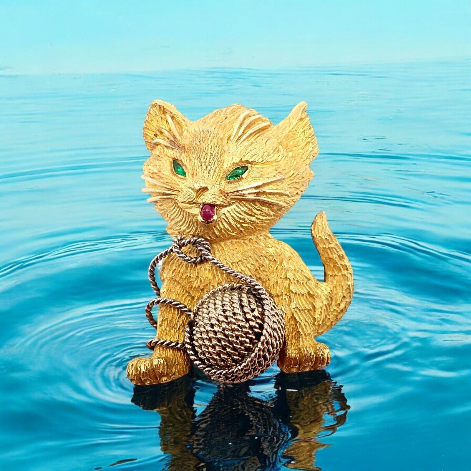 Broche en or jaune 20k rubis émeraude chat avec fil Tiffany & Co. 
La collection Tiffany & Co. France 20k Yellow Gold Ruby Emerald Cat Yarn Brooch est une pièce enchanteresse. 
Réalisé en or jaune 20k, il représente un chat espiègle aux yeux