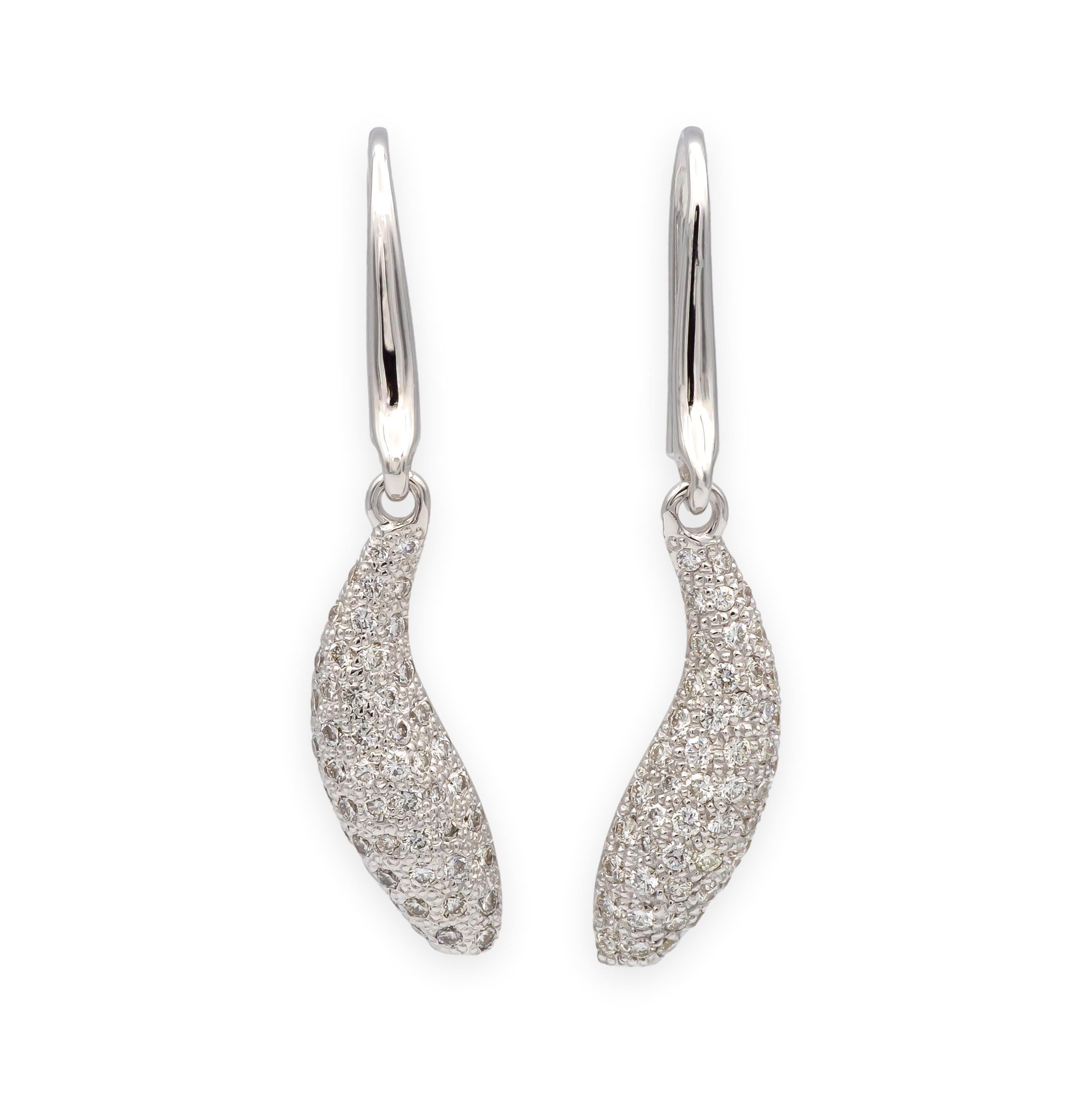 Vintage Sculptural dangle earrings from Tiffany & Co.’s Frank Gehry collection, crafted in 18K white gold and shaped as sleek “Fish” drops. Each earring is pavé-set with round brilliant diamonds totaling approximately 1.00 carat, and suspends from