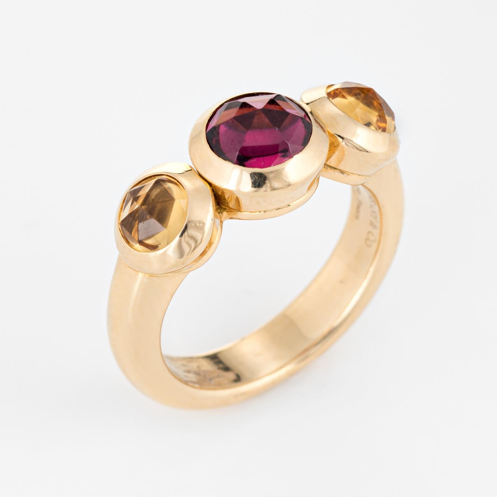 Estate Tiffany & Co garnet & citrine ring crafted in 18 karat yellow gold (circa 1990s to 2000s).  

Faceted garnet measures 6mm, flanked with two citrines that measure 4mm each. The stones are is in excellent condition and free of cracks or