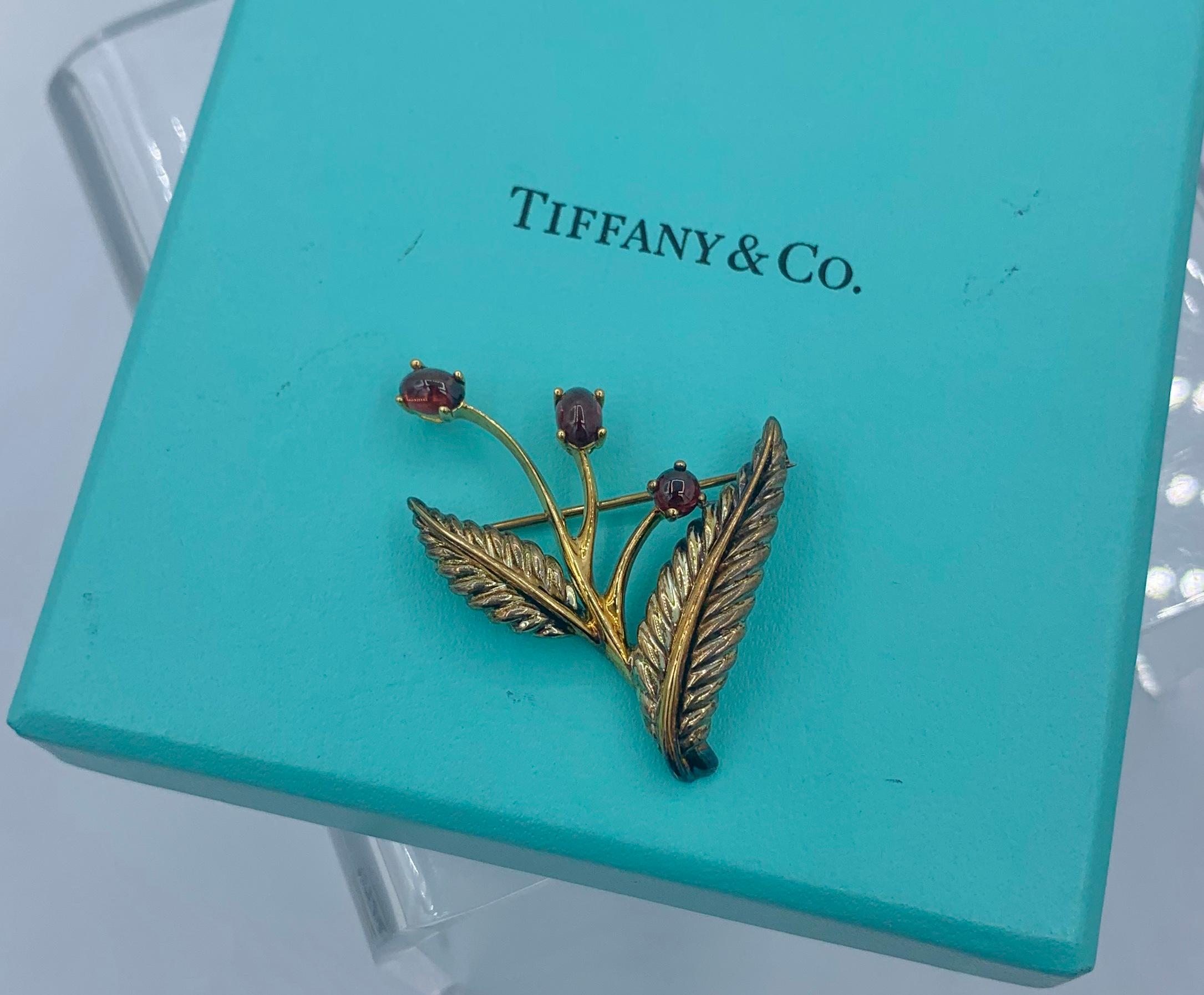 Dies ist ein reizvolles Vintage-Geschirr von Tiffany & Co. Brosche mit Granat-Blumenmotiv aus 18 Karat Gelbgold und Sterlingsilber, datiert auf 2003.  Die wunderbare Blume besteht aus drei ovalen und runden Cabochon-Granat-Edelsteinen.  Die Granate