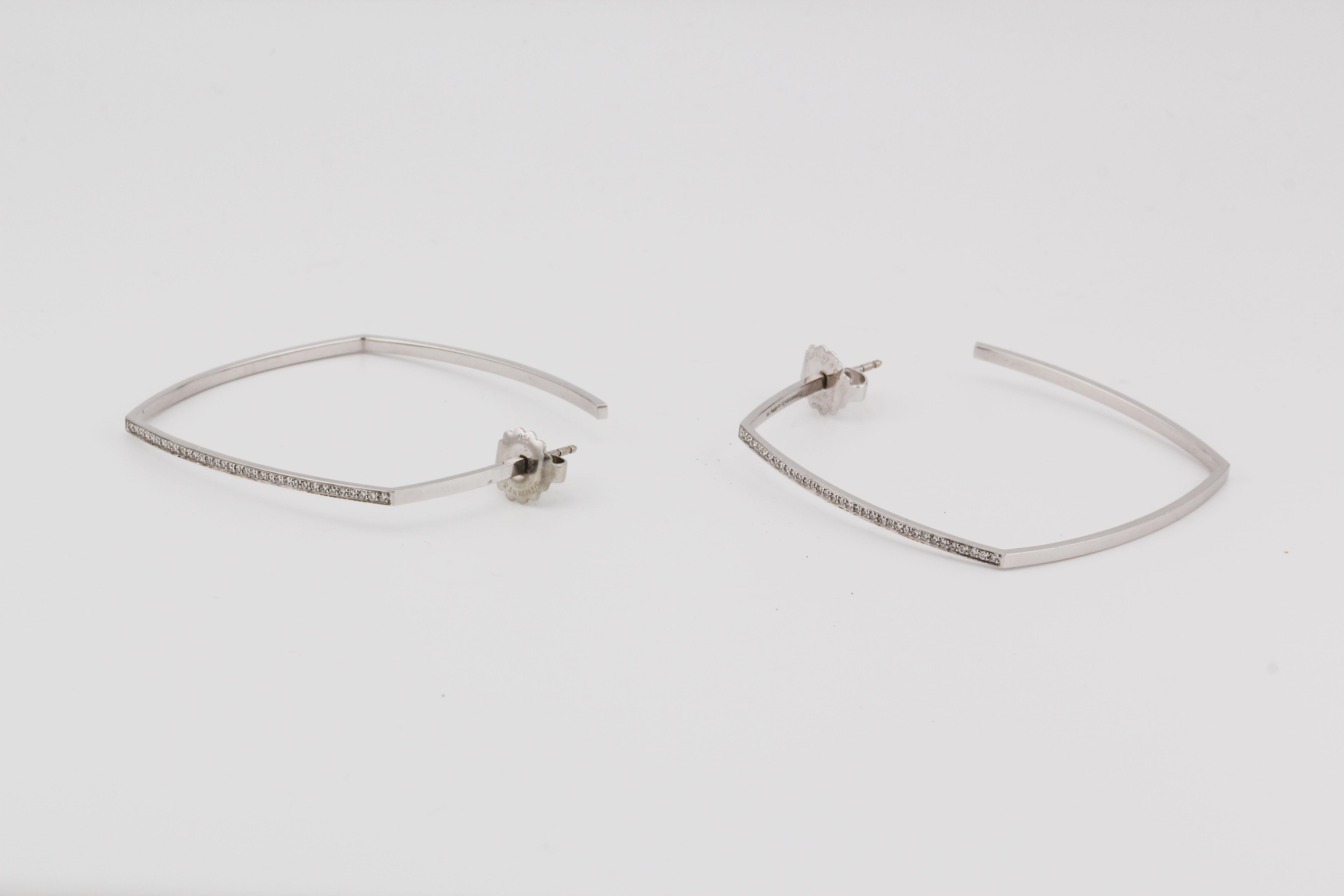 The Tiffany & Co. Gehry Torque Large Diamond Hoop Earrings are a bold and contemporary expression of luxury, designed by the legendary architect Frank Gehry for Tiffany & Co. These striking hoops are crafted from radiant 18k white gold, known for