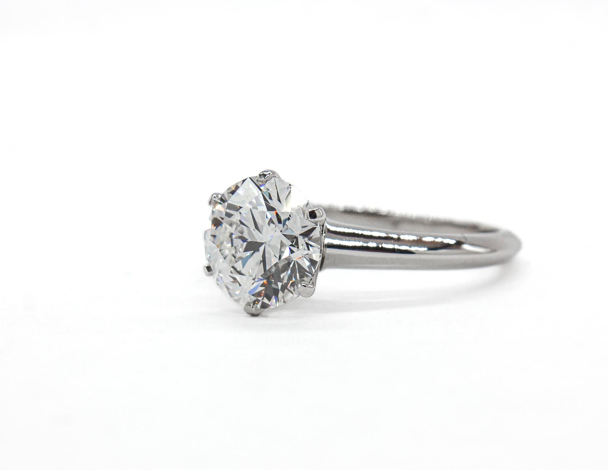 Un classico senza tempo di Tiffany & Co. Questo anello solitario in platino mette in mostra l'eleganza e la maestria del marchio. Il cuore di questo gioiello è uno spettacolare diamante tondo brillante da 2,00 carati, certificato da GIA con colore G