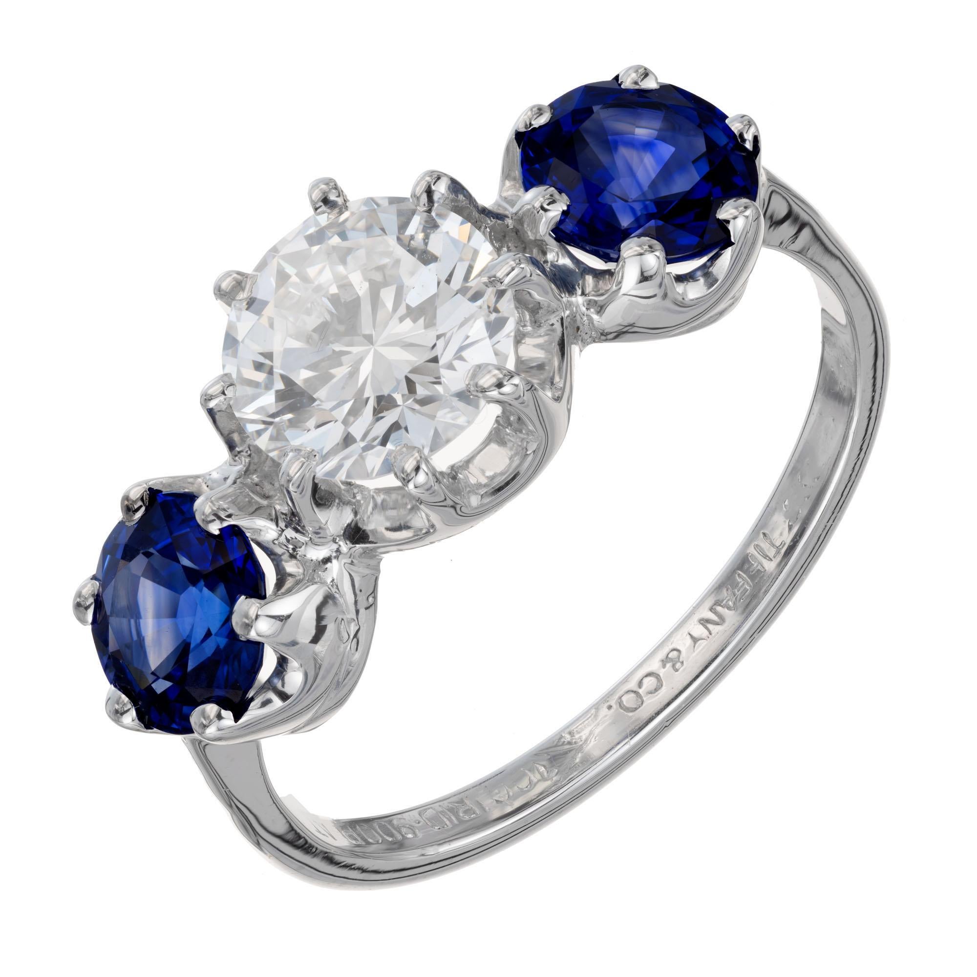 Tiffany & Co platinum vintage 1960's diamond and sapphire engagement ring. GIA Certified round center diamond with two side round sapphires, set in a platinum three-stone setting. 

1 round brilliant cut diamond D VS2, approx. 1.11cts GIA