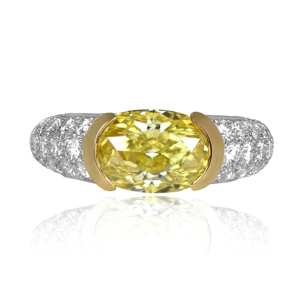 Cette bague de fiançailles Tiffany est ornée d'un superbe diamant de taille ovale Fancy Intense Yellow certifié par le GIA, habilement serti dans des demi-bézels d'or jaune 18 carats. La tige et le dessous de la galerie de la bague sont ornés de