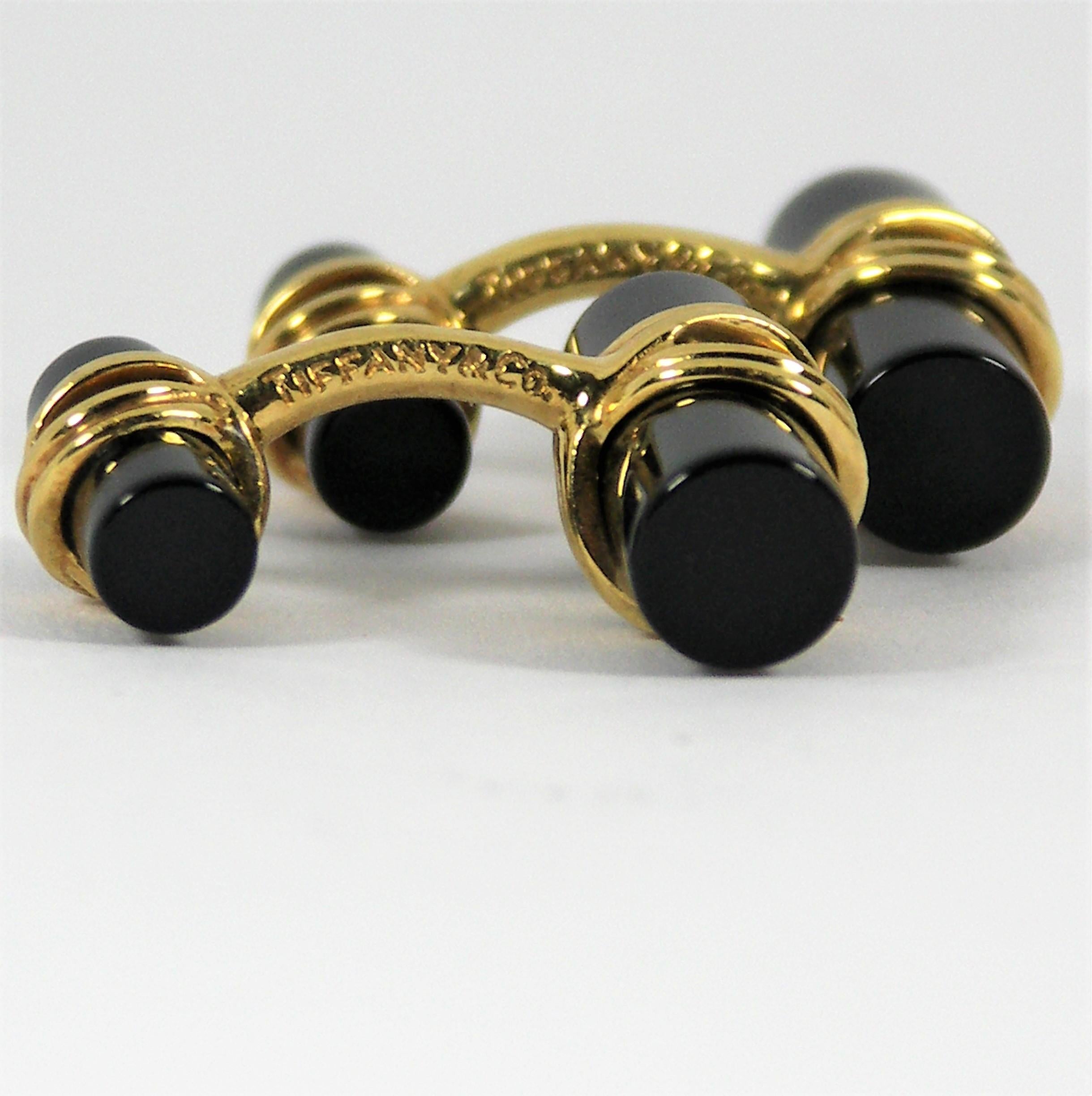 Ces boutons de manchette classiques en onyx, de style double bâton, en or jaune 18 carats de Tiffany & Co 
sera un excellent ajout à la collection de tout homme. Ils mesurent 1 pouce de long par 13/16 pouce
en largeur. Poids brut 13 grammes.  