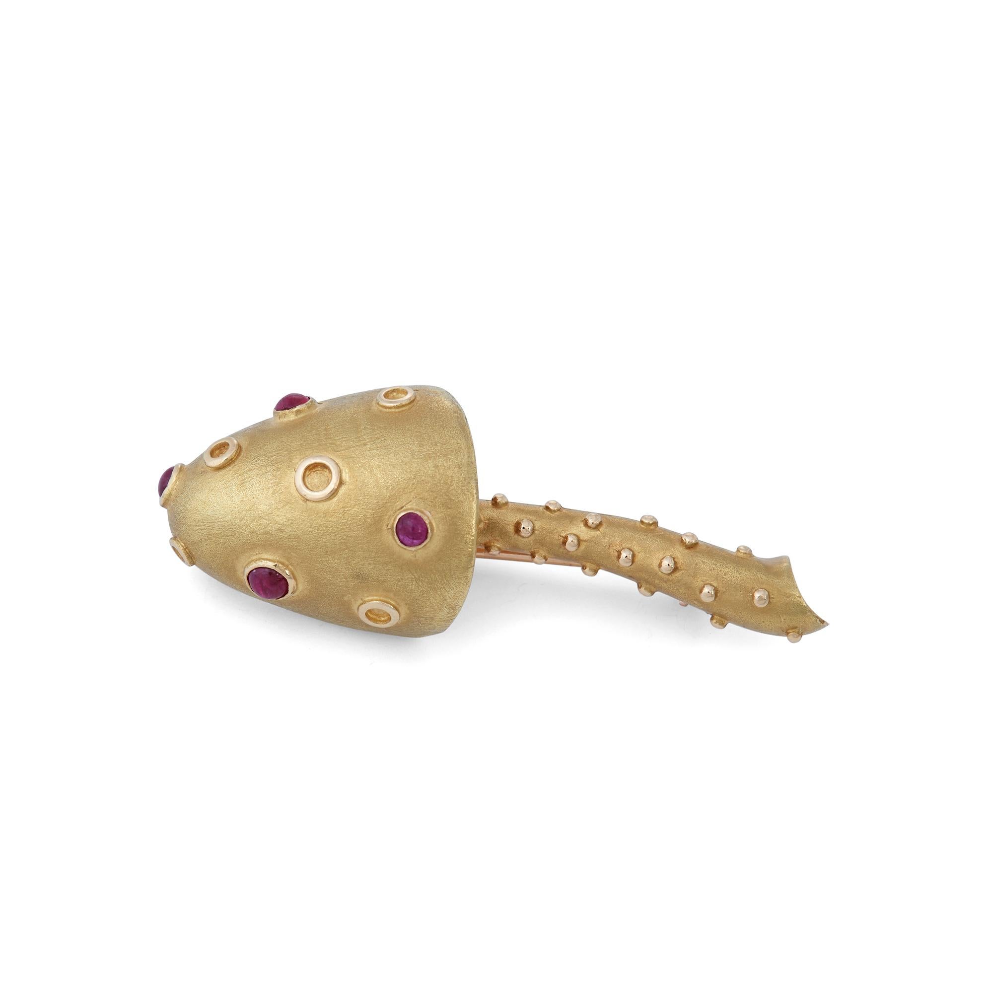 Authentic Tiffany & Co pin crafted in 18 karat matte textured yellow gold. The whimsical mushroom design is set with four cabochon rubies on the mushroom cap. The brooch measures 2 inches in length and .71 inches at the widest point.  Signed Tiffany