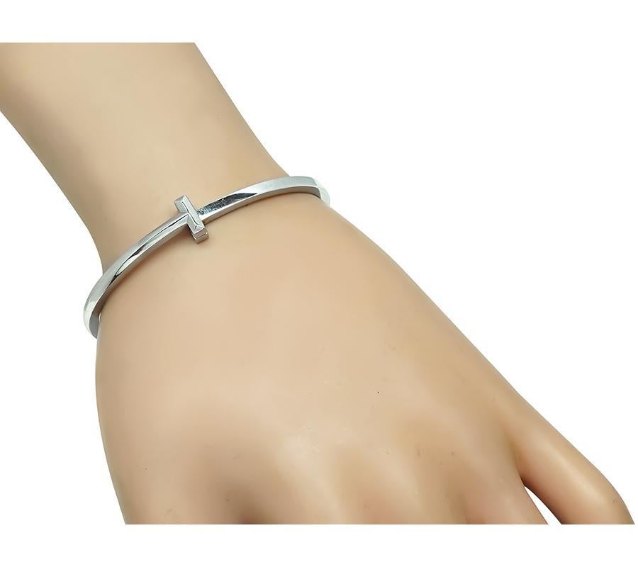 Este es un encantador brazalete de oro blanco de 18 quilates de Tiffany & Co. El brazalete mide 3 mm de ancho y pesa 23,7 gramos. El brazalete está firmado Tiffany&Co Au750 Italia.