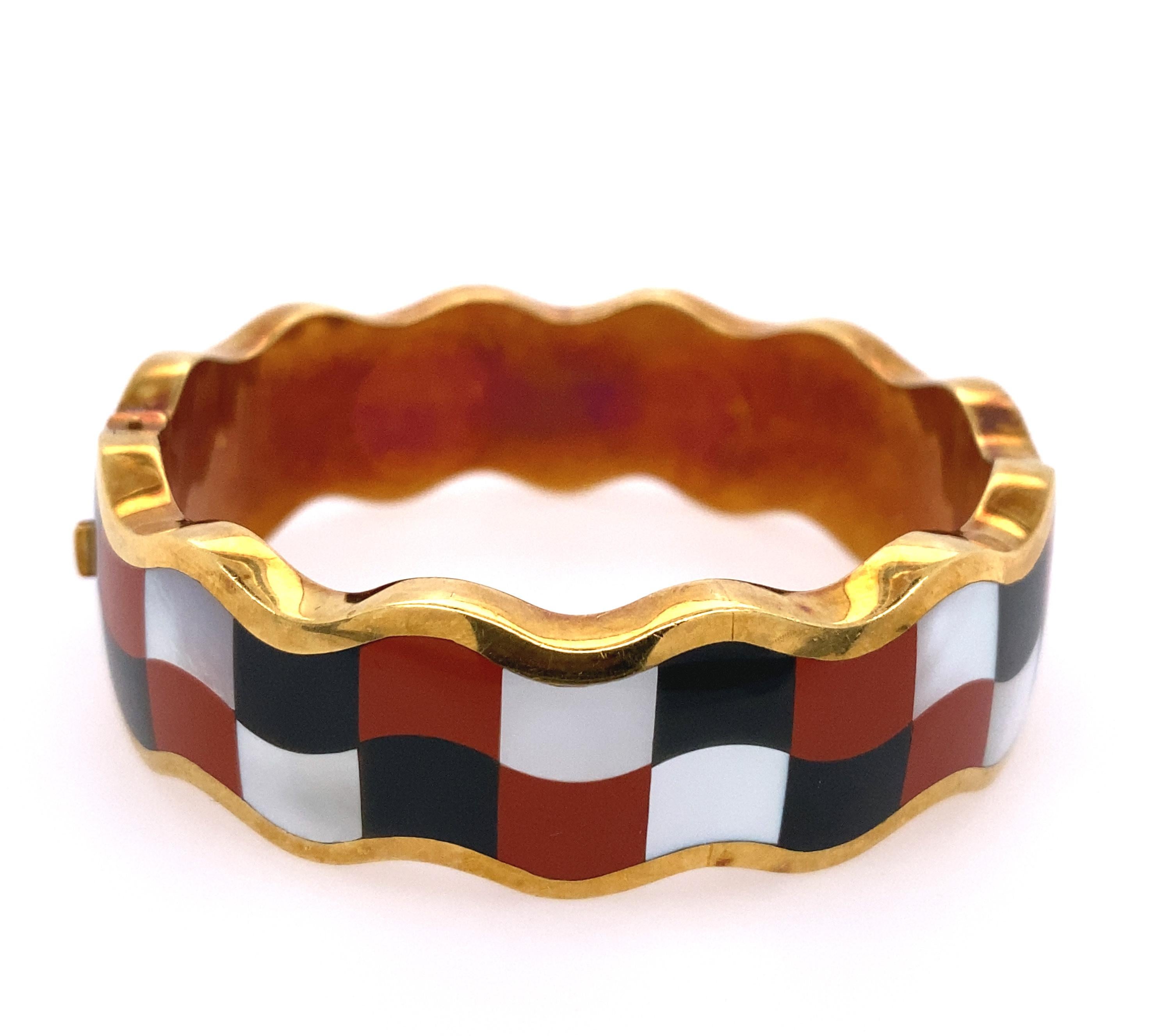 Tiffany & Co, Gold, Black Jade,  Mother-of-Pearl and Jasper 'Checkboard' Bangle bracelet. 
18k, the wavy bangle inlaid with check board pattern of black jade, mother of pearl and jasper way rectangles, signed Tiffany & Co.
Total weight  35.1 dwt.