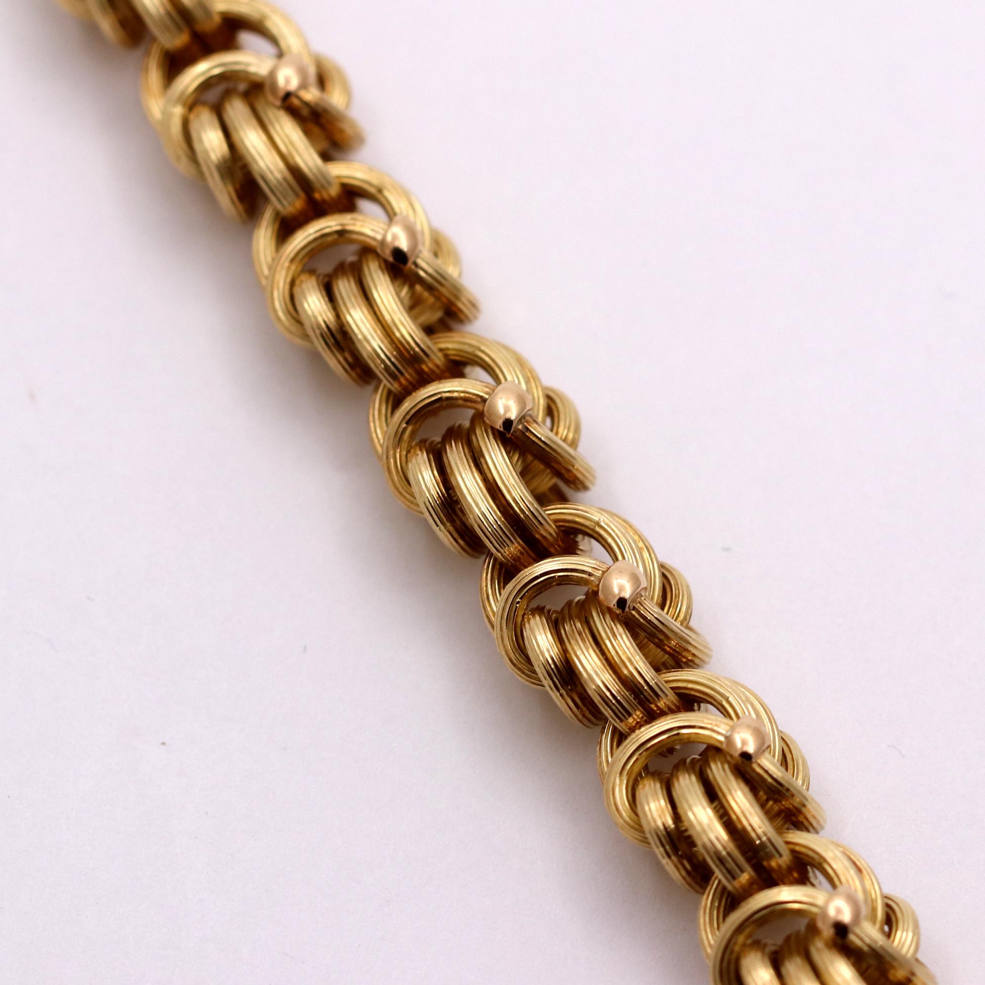 An 18K yellow gold bracelet by Tiffany comprised of ribbed Byzantine links, each with a high polished bead motif. This subtly styled, and detailed bracelet will fit wrists up to 7 1/4 inches. Measuring 1/2 an inch wide and 8 inches long, this
