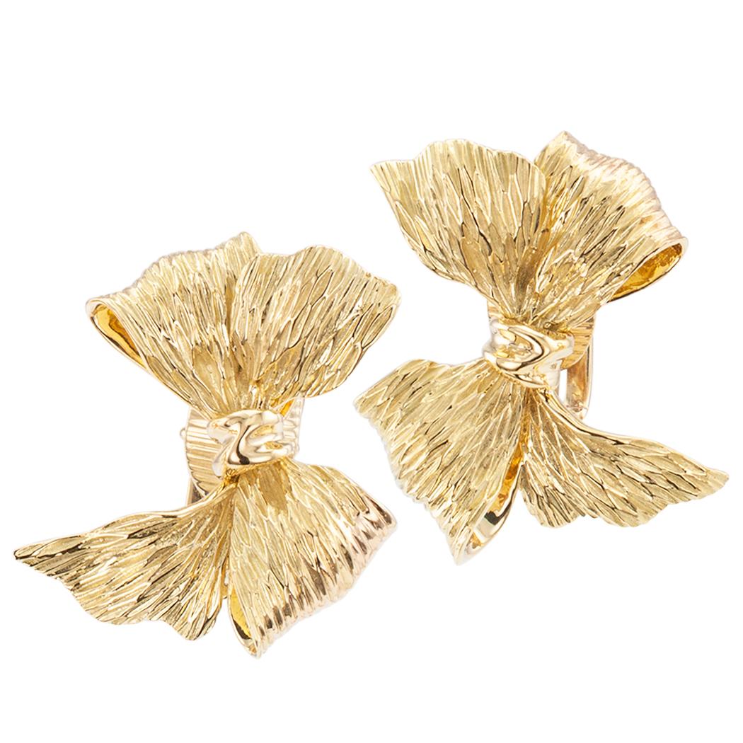 Tiffany & Co. gold bow earrings circa 1960. The matching left and right designs comprise a pair of dimensional and textured gold bows crafted in    18 karat yellow gold with clip backs, signed Tiffany & Co. Very pristine condition consistent with
