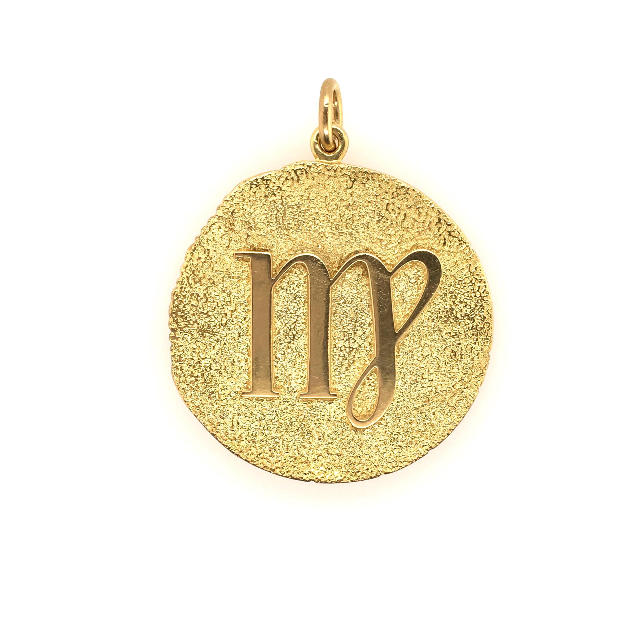 An 18 karat yellow gold and diamond “Virgo” pendant.  Signed Tiffany, Italy.  The pendant is set with (3) three circular shape diamonds next to a man’s profile on one side, and the symbol for Virgo on the other side.  Gross weight approximately 48.8