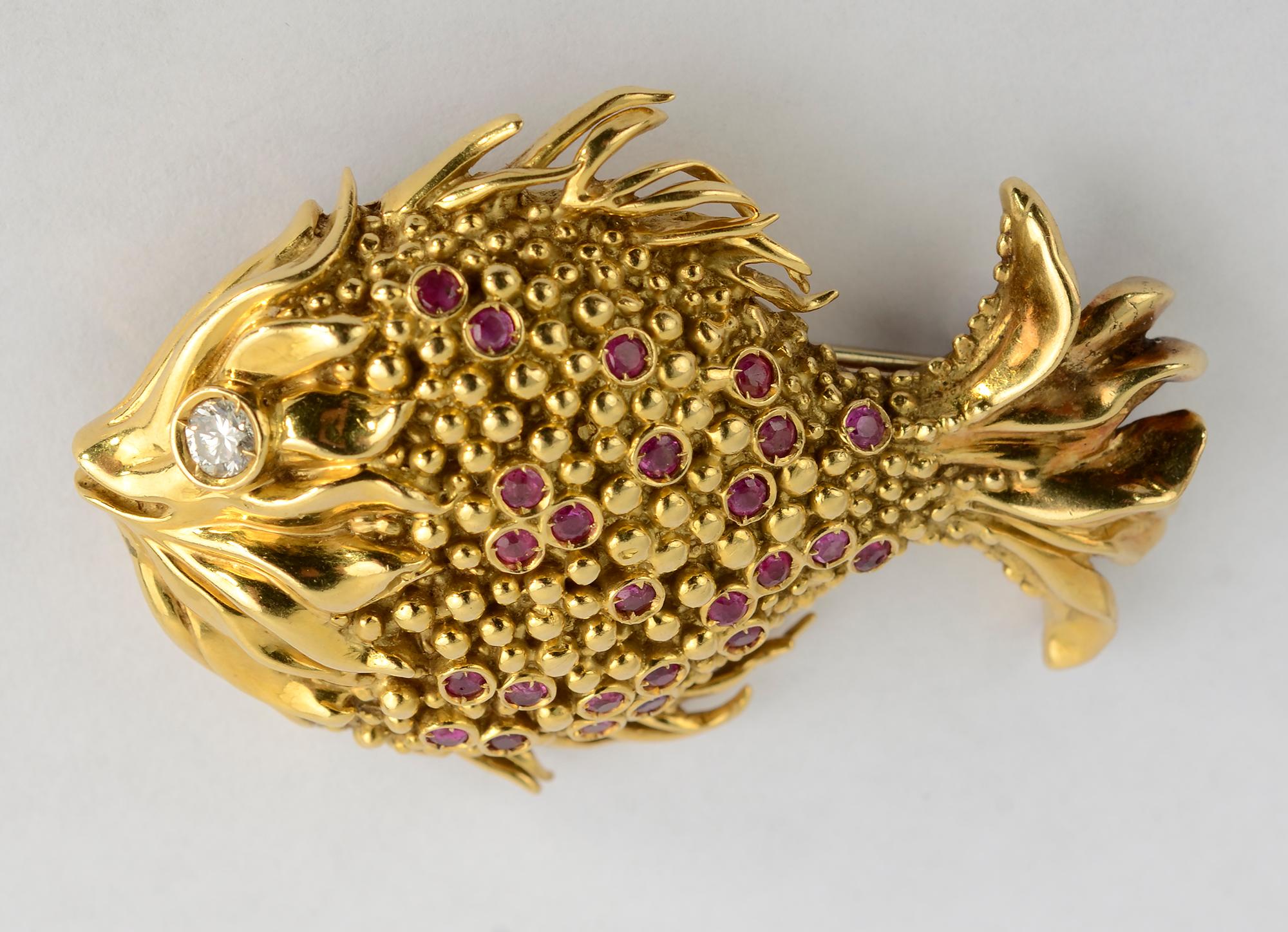 Wonderfully whimsical gold fish brooch by Tiffany with ruby highlights throughout the body and a .13 carat diamond eye. The fins and face have ruffled features while the body is made of very small gold beads giving a terrific texture. The fish