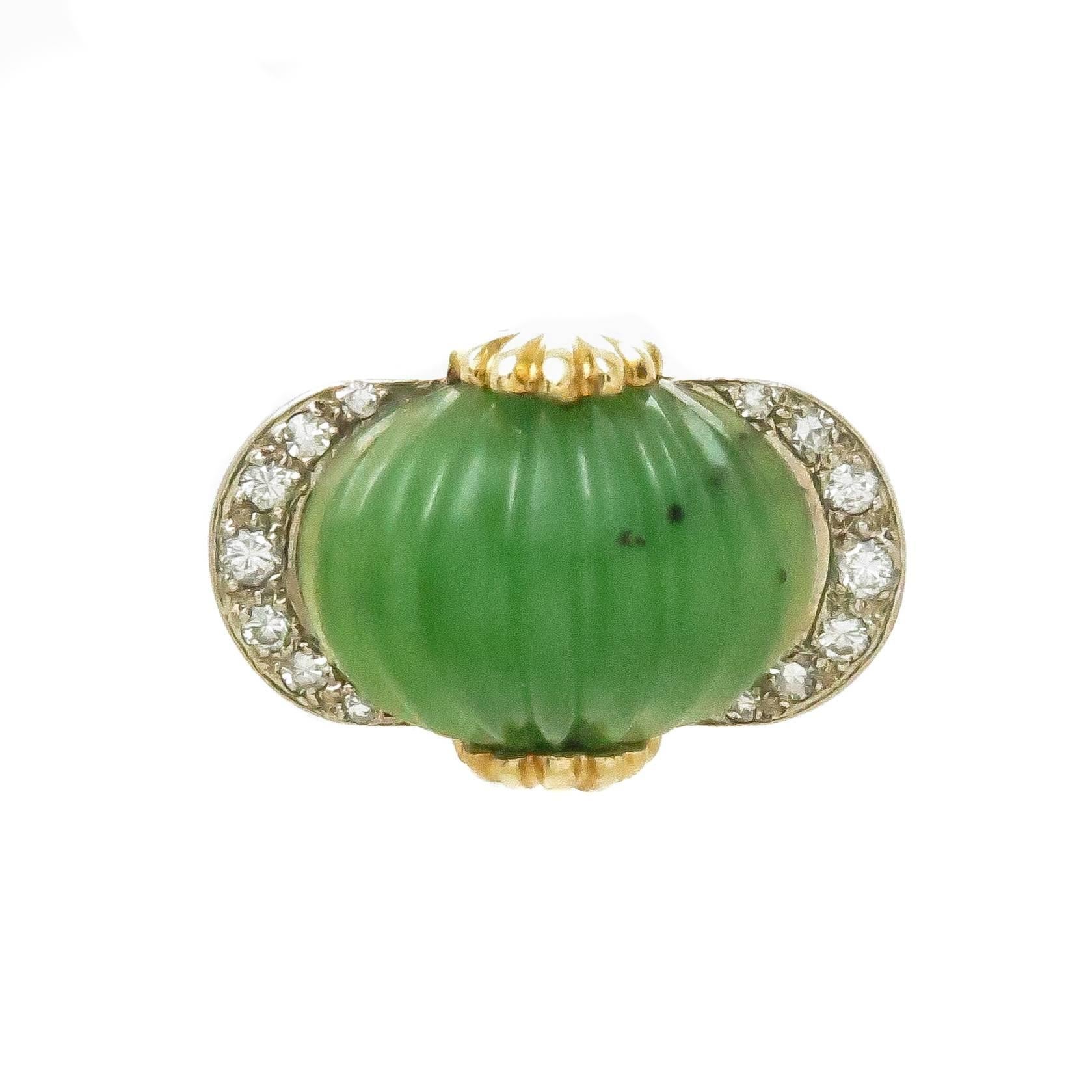 Circa 1970s Tiffany & Company 18K Yellow Gold Ring, centrally set with a Scallop carved Jade measuring 15 X 10 MM, set on either side are Round Brilliant cut Diamonds totaling .25 Carat. The ring top measures 7/8 inch in length.  Finger size 5 1/2. 