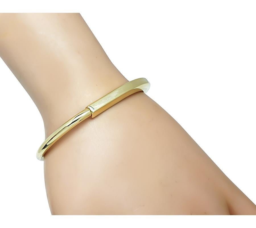 Si tratta di un favoloso braccialetto con lucchetto in oro giallo 18k di Tiffany & Co. Il braccialetto misura 6 mm di larghezza alla base più larga e si adatta a un polso di dimensioni standard. Il braccialetto è firmato TIFFANY & Co. Au 750 ITALY e