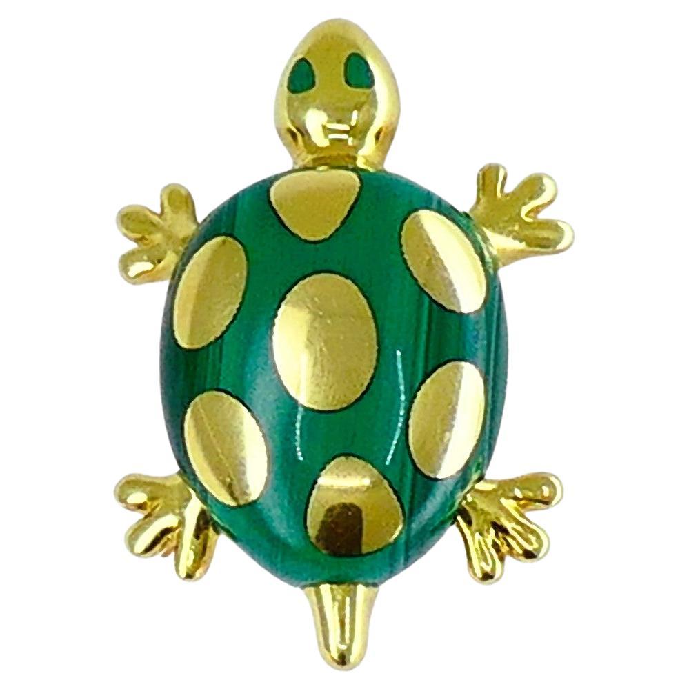 A cute set by Tiffany & Co. made of 18k gold and malachite, consisting of a brooch and matching earrings.
The turtles’ malachite shells are playfully dotted with gold circles. Heads and bodies are made of gold, with eyes accented with malachite.