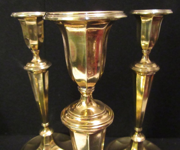 Set of four modern Tiffany & Co. gold-plated sterling silver candlesticks. Excellent condition. Made by T&Co. in England. Urn socket with detachable bobeche, tapering columnar shaft, knops, and stepped foot. Spare form embellished with reeding. The