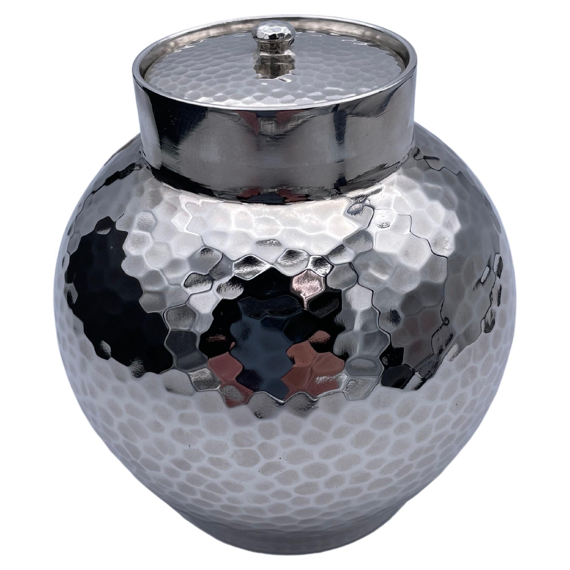 Outstanding tea caddy or covered jar. Made by Tiffany & Co. Solid gauge sterling silver with an allover deep hand-hammered finish. 
A graceful rounded shape. It has a separate lid with a small knob. 4 1/2