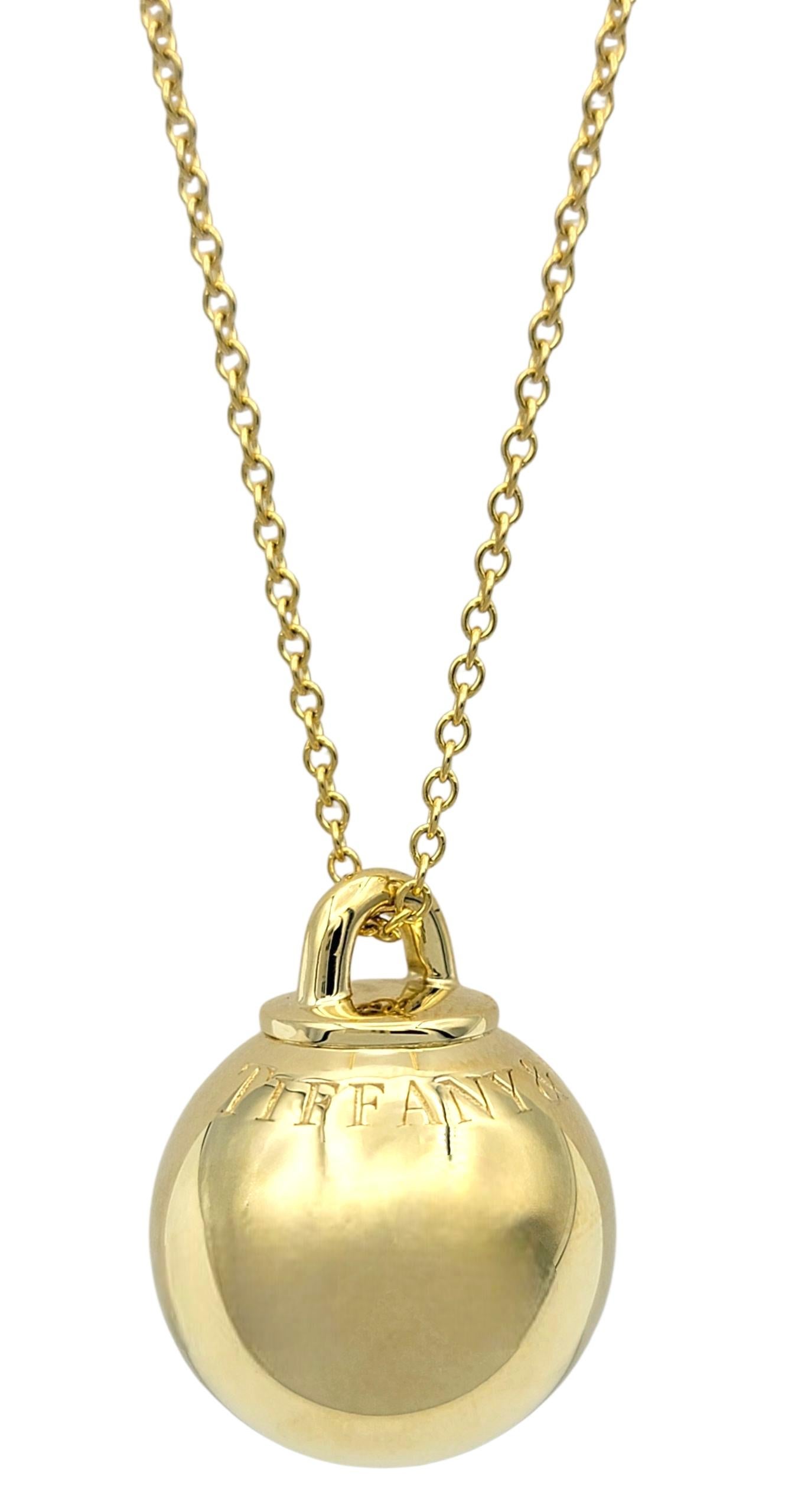 This statement necklace from Tiffany & Co.'s iconic HardWear collection features a bold, high-polish ball pendant in radiant 18 karat yellow gold. The oversized sphere hangs from a long rolo-style chain, offering a modern yet timeless silhouette