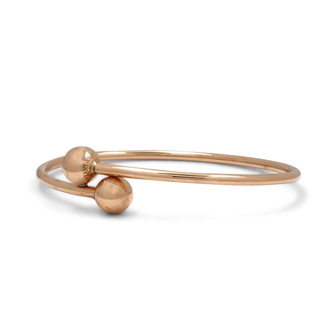Authentic Tiffany & Co. 'HardWear Ball Bypass' bangle bracelet crafted in 18 karat rose gold. Will fit up to 5 1/4 inch wrist. Signed Tiffany & Co., Au750, ITALY on the base of the bangle and 'TIFFANY & CO', 'NEW YORK' on the ball ends. The bracelet