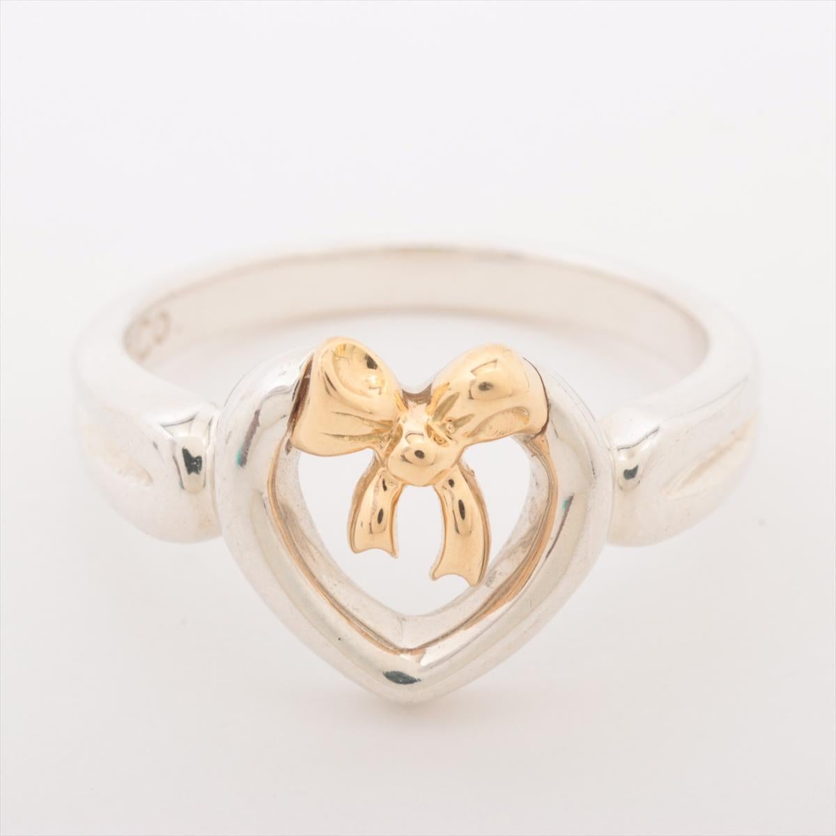 The Tiffany & Co. Heart Bow Two-Tone Ring is a graceful and romantic piece that blends classic elegance with modern charm. Featuring a delicate heart shaped with bow design, the ring is crafted in two-tone metals, adding a unique contrast and