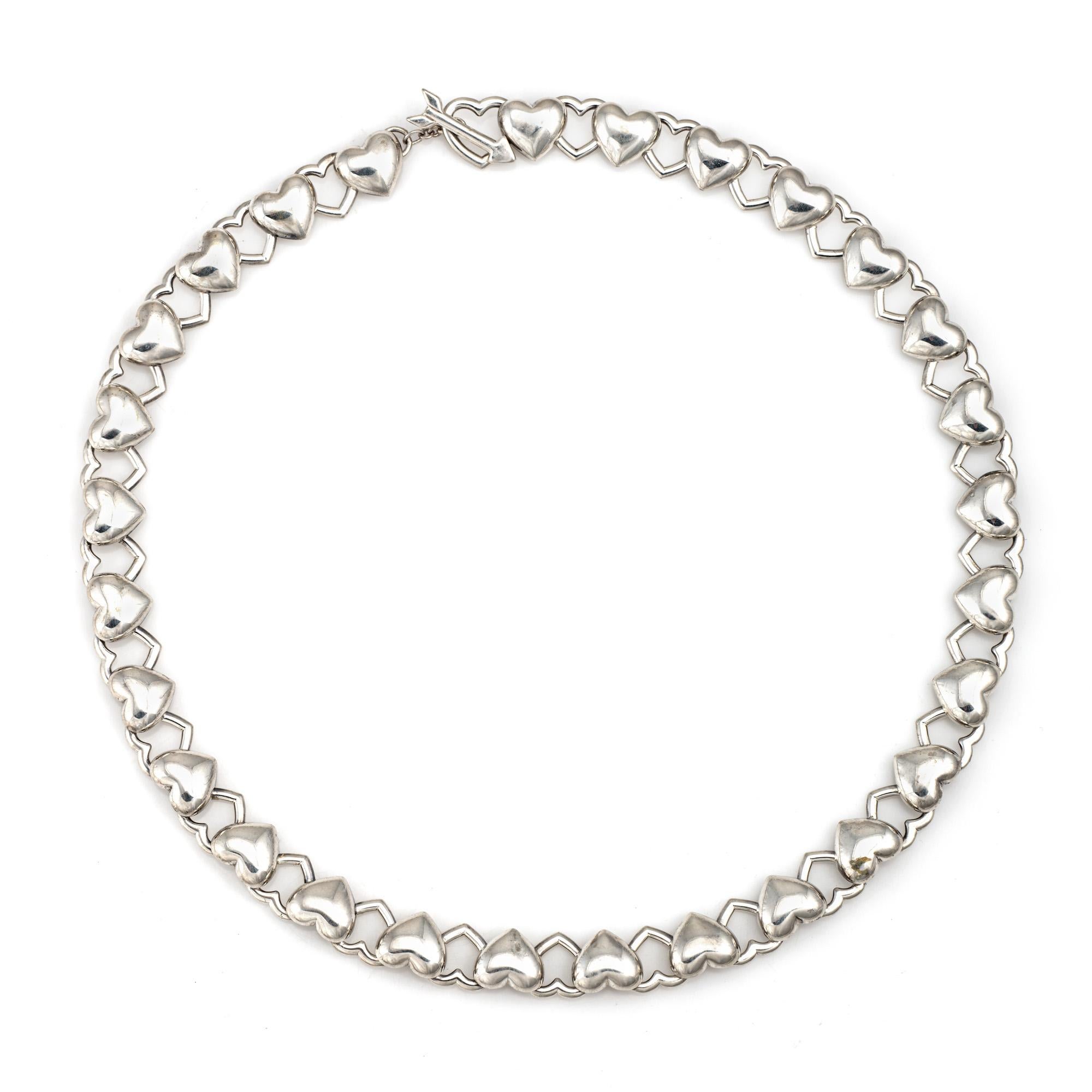 Stylish and finely detailed vintage Tiffany & Co 'cupid's arrow' heart link necklace, crafted in sterling silver.  

The beautiful heart link necklace is finished with a cupid's arrow toggle clasp. Measuring 15 1/2 inches in length the necklace sits
