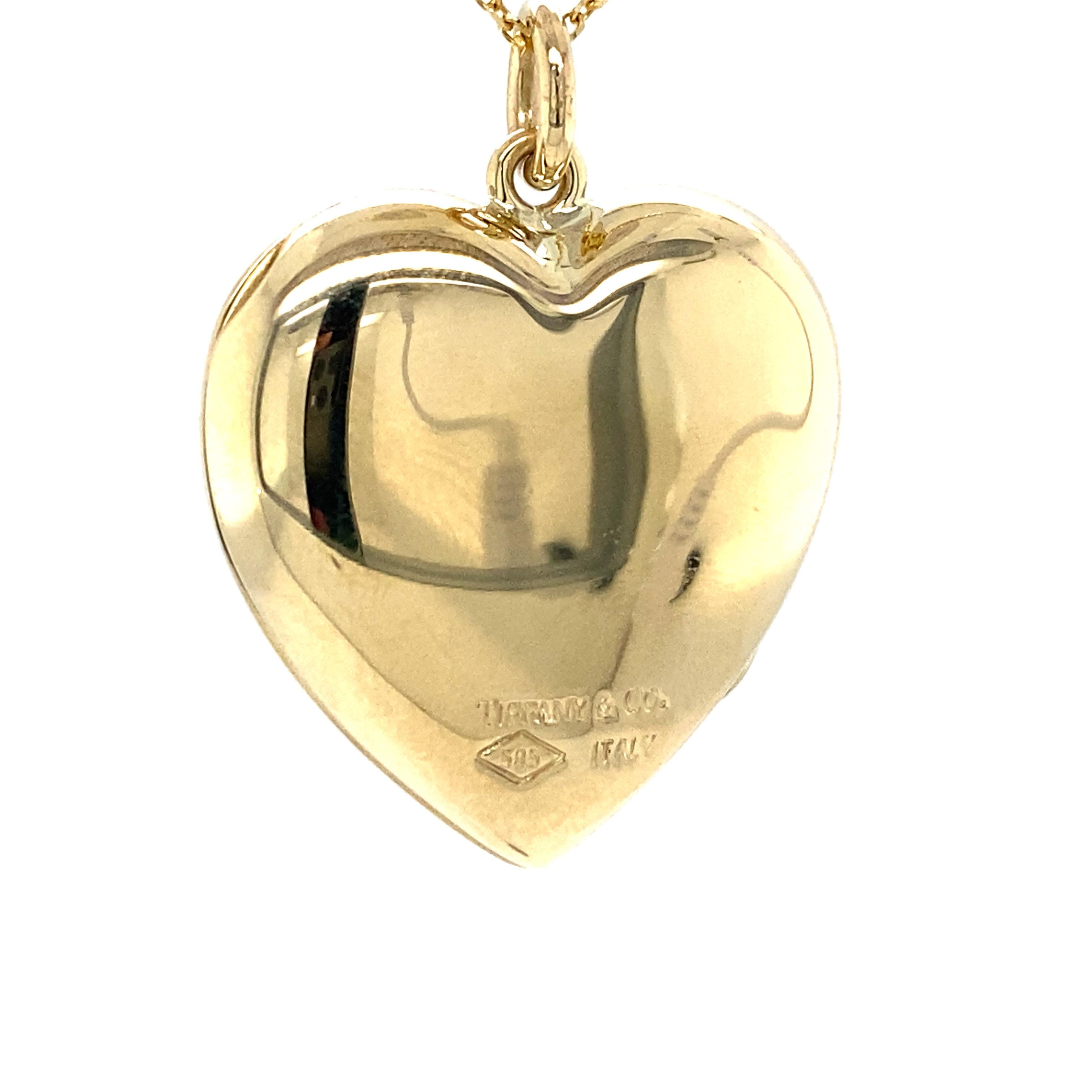 Tiffany & Co Heart Shape Locket in 14K Yellow Gold.  The locket measures 1 1/4 inch in length and 1 1/8 inch in width. 10.10 grams.  Signed.  Chain not included. T & Co. felt bag and blue box included.