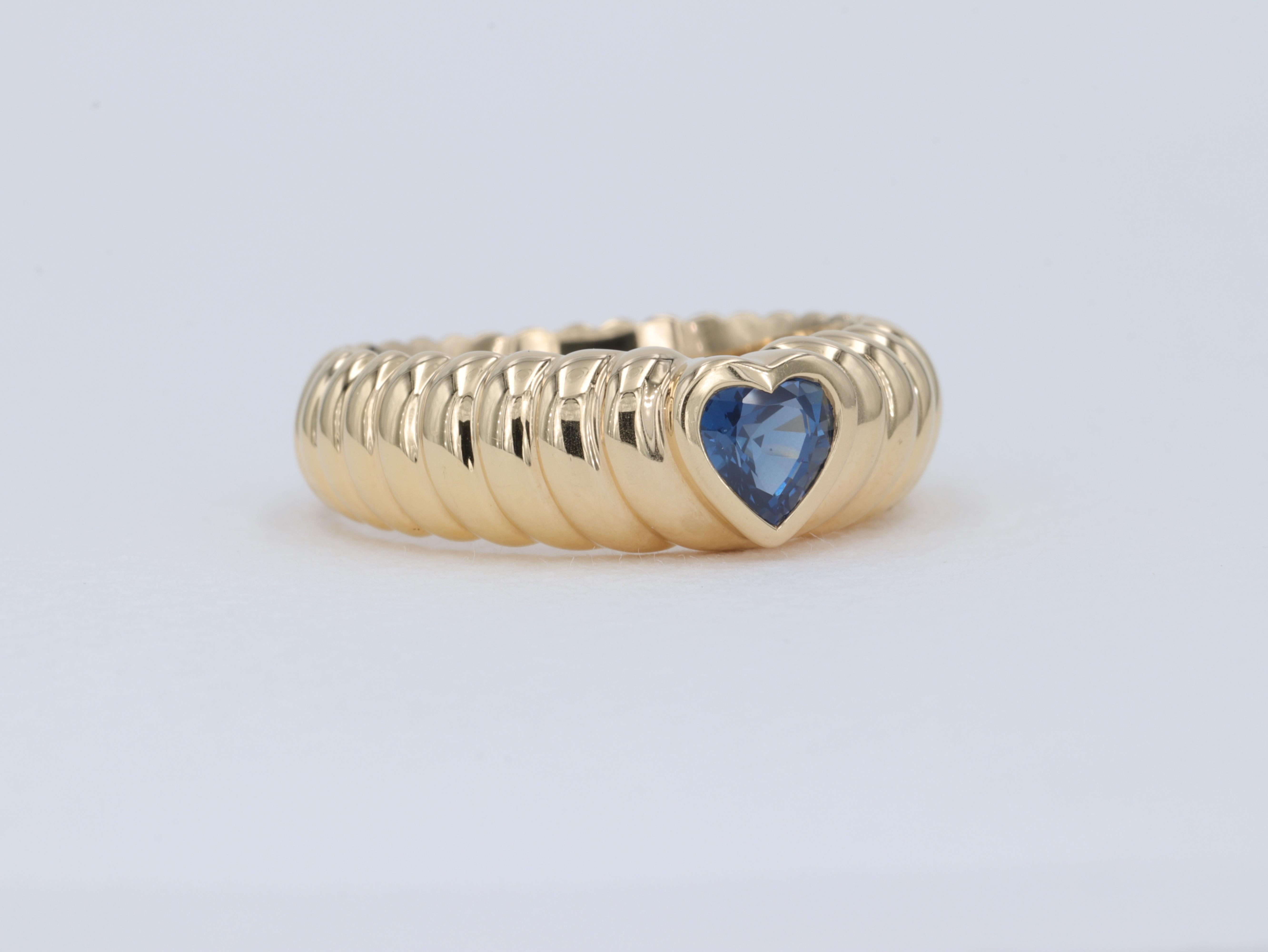This heart motif ring by Tiffany & Co. features a heart shape blue sapphire center stone with a domed finish that gives the appearance of waves moving away from the center stone. 

The sapphire is a vivid blue color and weighs approximately .50