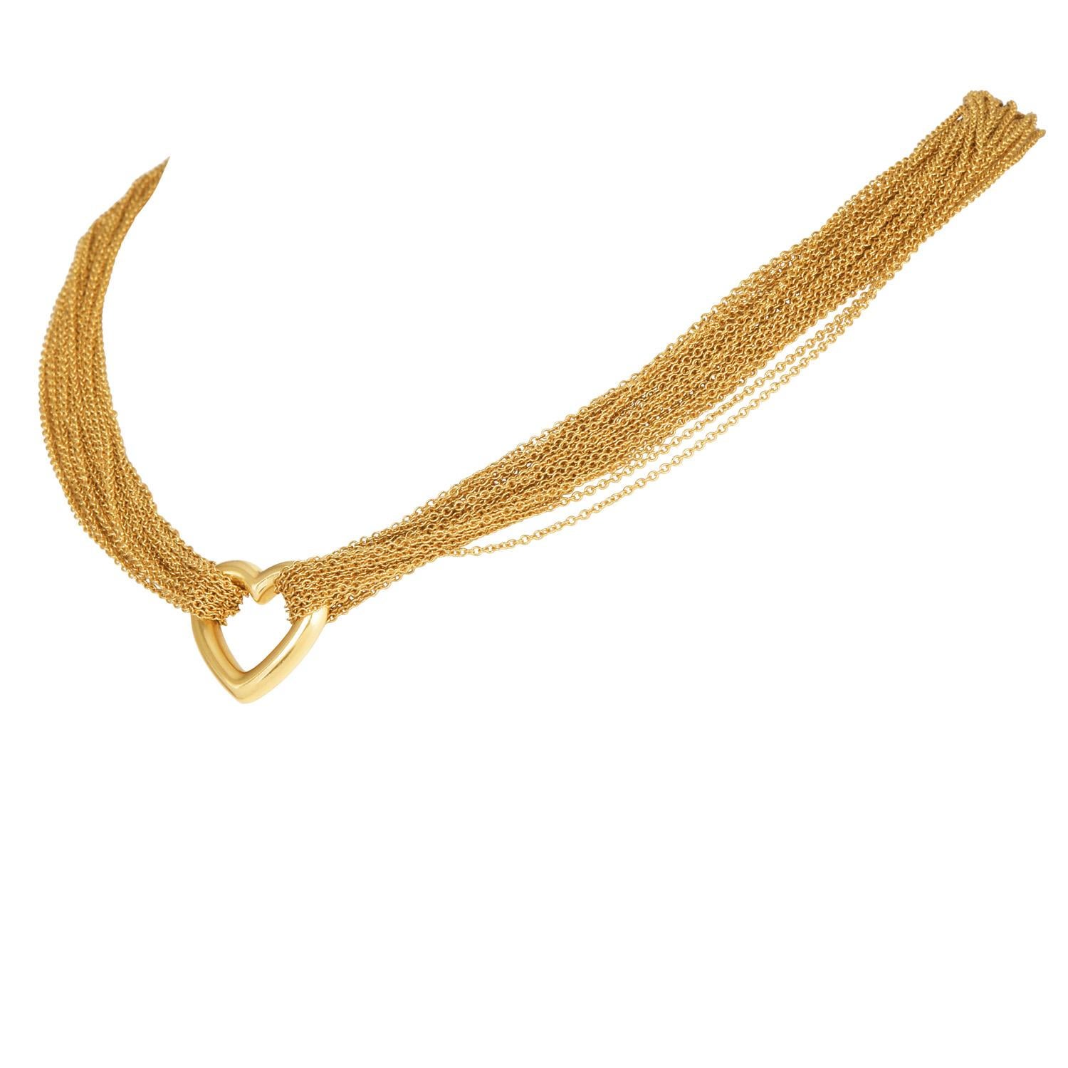 Questa splendida collana con alamari a forma di cuore di Tiffany & Co., realizzata in oro giallo 18 carati, presenta diverse catene d'oro intrecciate tra loro e termina con una chiusura ad alamari a forma di cuore che trasuda raffinatezza. L'accento