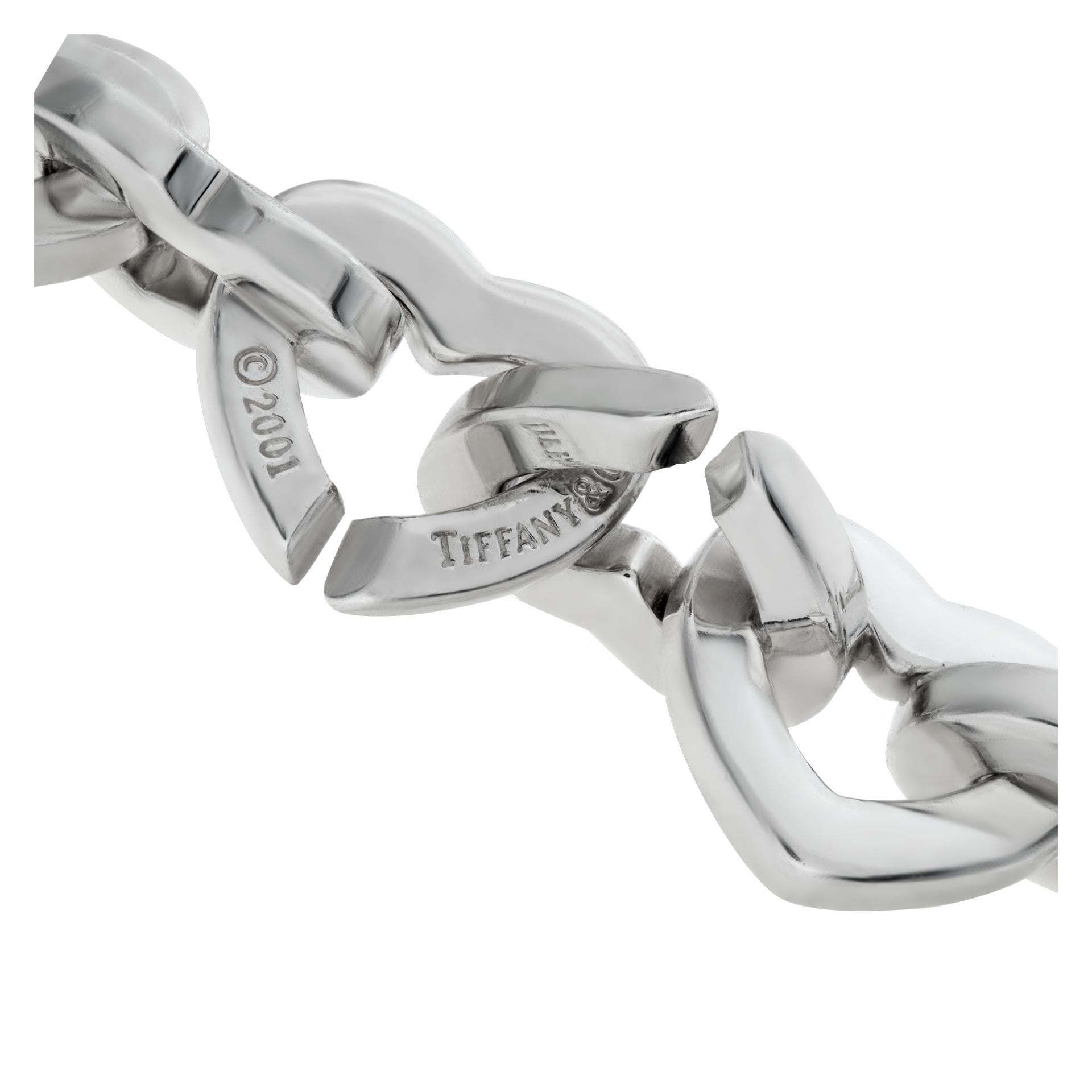 Tiffany & Co. Heart bracelet with sterling silver and one 18k yellow gold heart-shaped link. Length 7 inches, width 10mm - 14mm.
