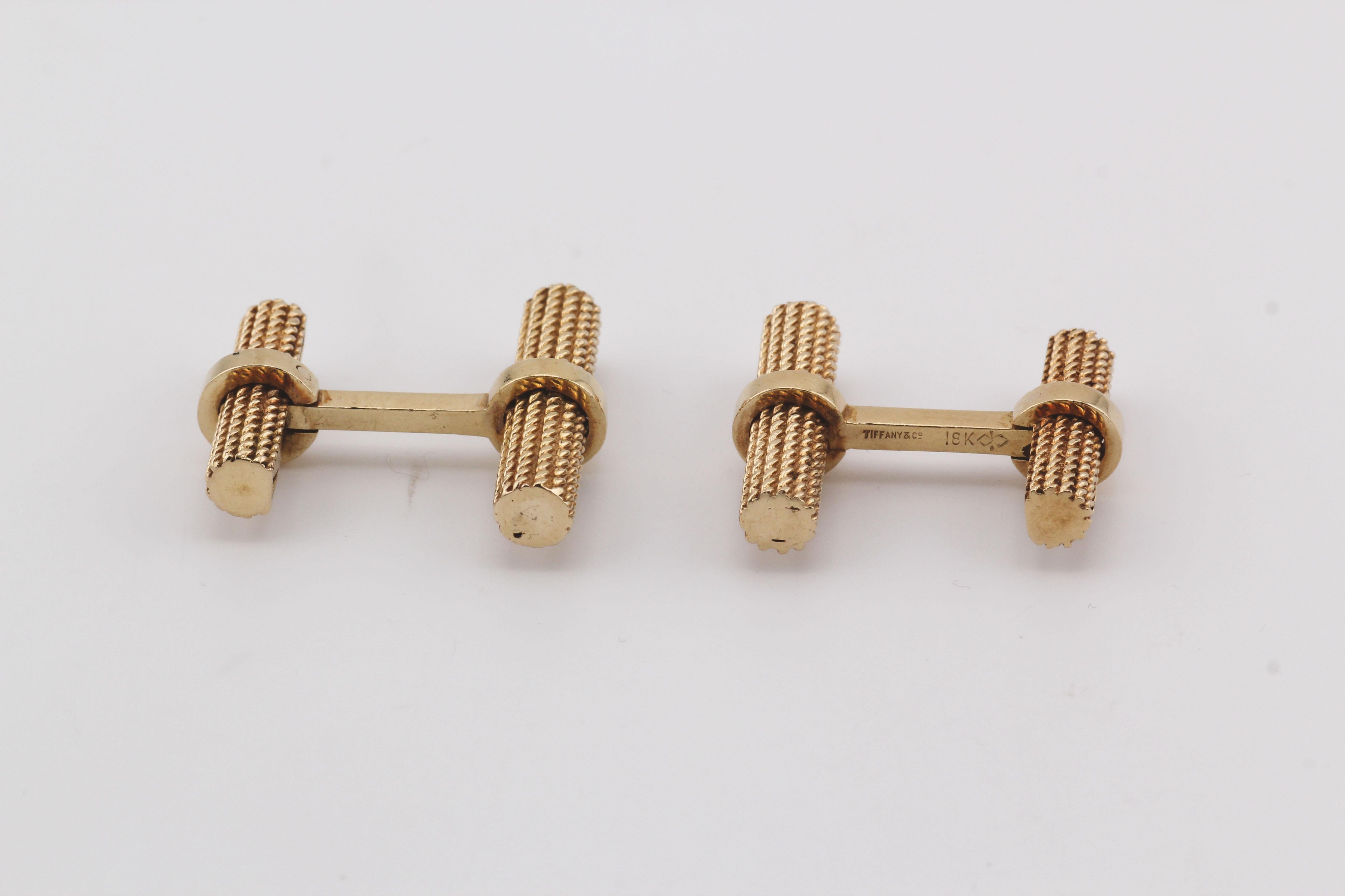 Die Tiffany & Co. Manschettenknöpfe sind ein Musterbeispiel für raffiniertes Design und sorgfältige Handwerkskunst. Diese Manschettenknöpfe sind aus luxuriösem 18-karätigem Gelbgold gefertigt und haben ein raffiniertes und strukturiertes Aussehen.