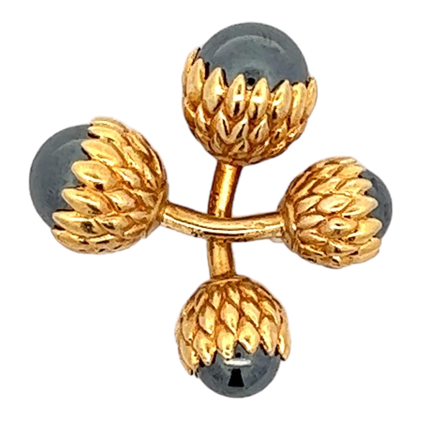 Tiffany & Co. hematite cufflinks fashioned in 18 karat yellow gold. The timeless cufflinks feature hematite gemstones set in textured yellow gold acorn designs. The cufflinks measure 1.25 inches in length, and 10.5mm in width at the ends; signed