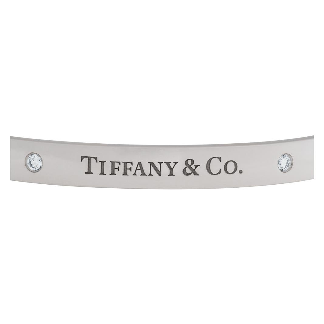 Tiffany & Co. Hinged bangle bracelet in 18k white gold with 2 full cut round brilliant diamond. Fits wrists up to 6.5