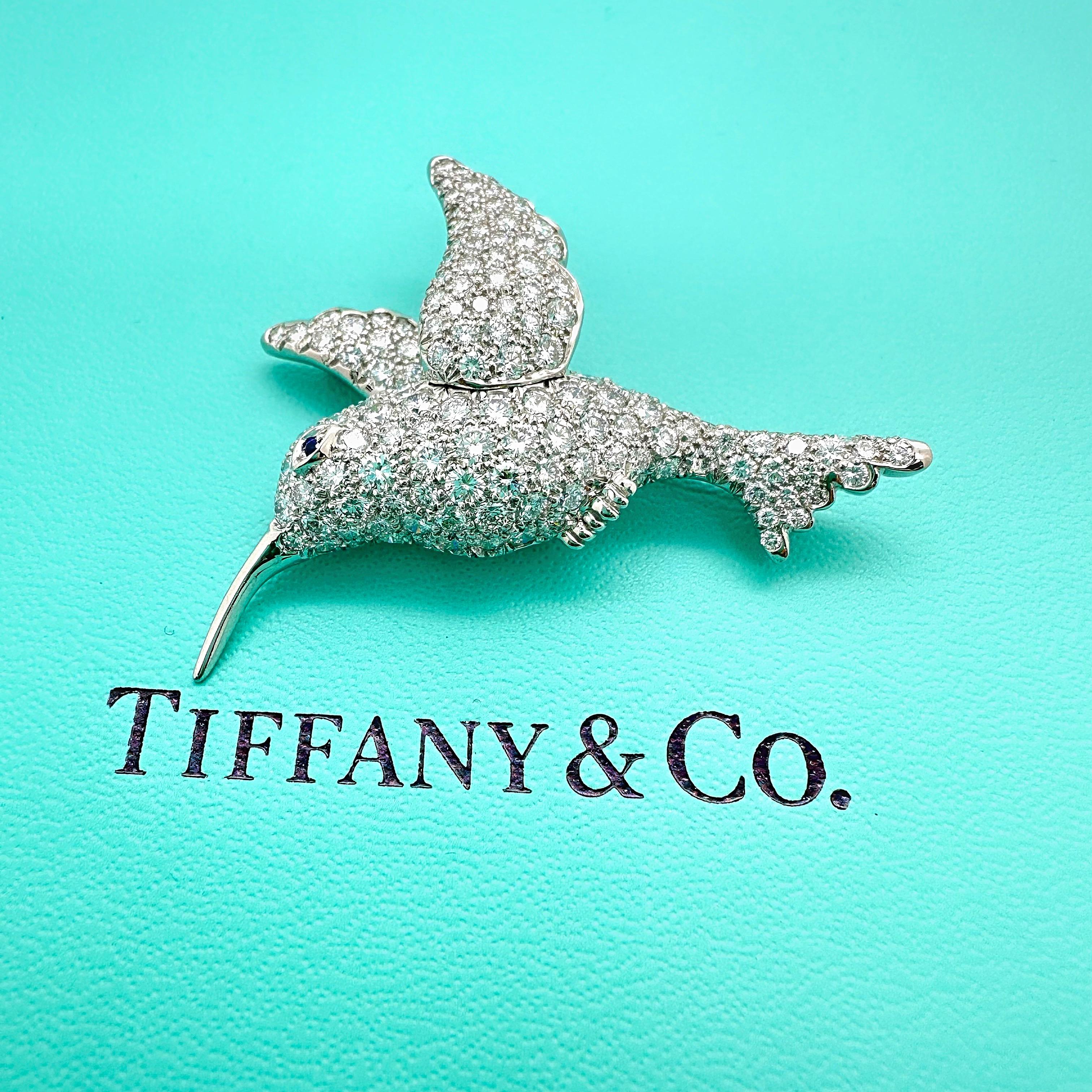 Tiffany & Co. Hummingbird Diamond Pin Brooch
Style: Vintage Pin / Brooch
Metal: Platinum PT950
Diamond Shape: Round Brilliant Diamonds & 1 Round Faceted Blue Sapphire 
Total Carat Weight: ~ 5.00 TCW
Dimensions: 2' x 1.5' Inches
Weight:  12.5