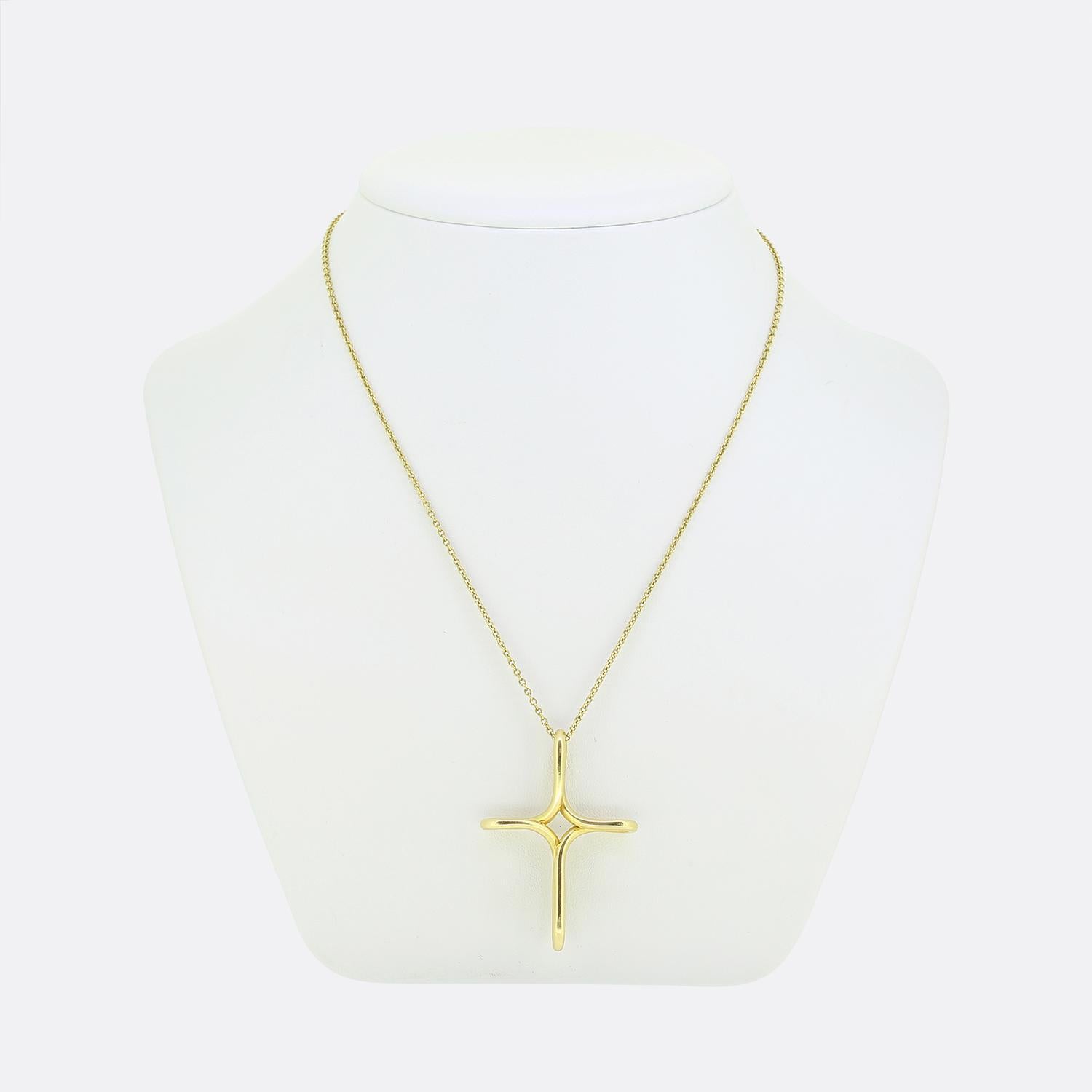 Here we have a chic and stylish necklace from the world renowned jewellery designer, Tiffany & Co. The pendant has been crafted from a rich 18ct yellow gold into the shape of a unique, flowing cross design. The smooth curves and polished finish