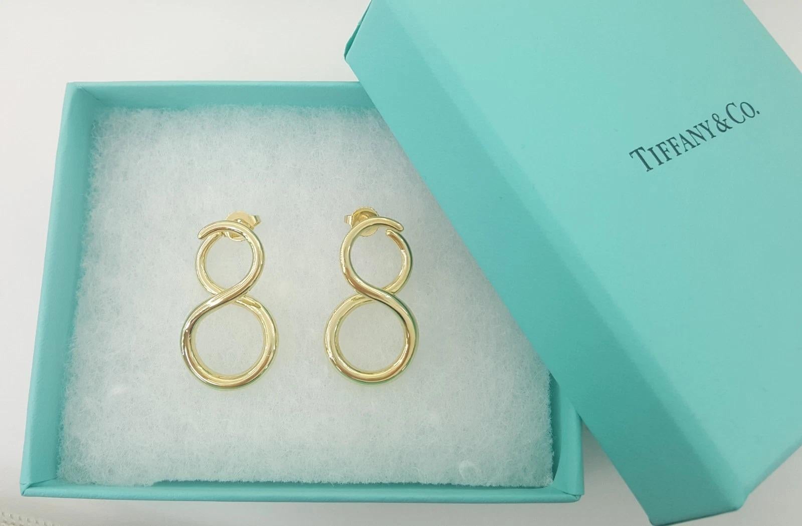 Tiffany & Co. Pendientes grandes Infinity de oro amarillo de 18 quilates - 14,3 g, 1,2 pulg.

Un diseño llamativo y atemporal de Tiffany & Co., estos auténticos pendientes Infinity encarnan la elegancia y la sofisticación. Fabricados en oro amarillo