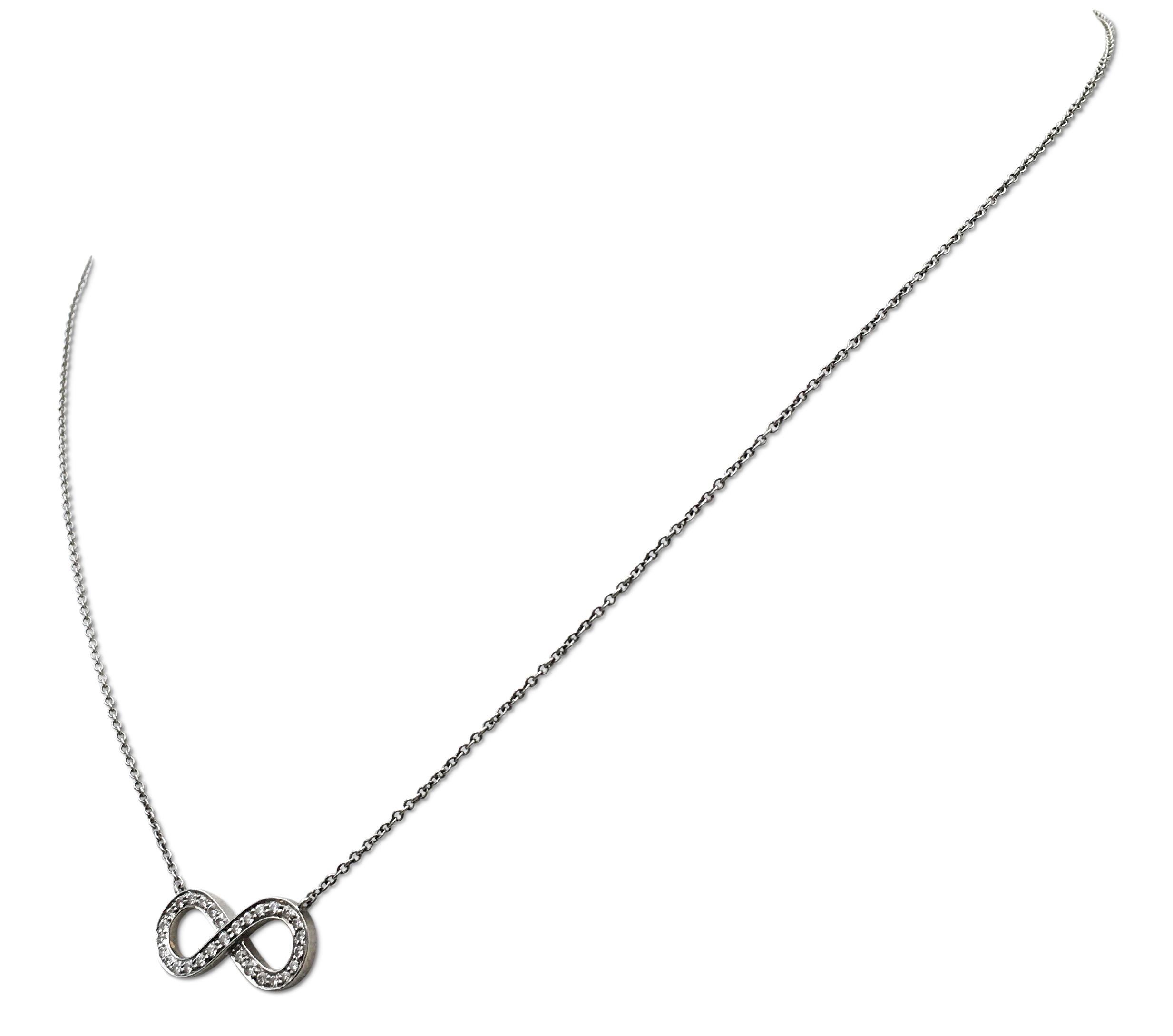 Authentic Tiffany & Co. necklace centers on the infinity sign crafted in platinum and set with an estimated 0.15 carats of high quality round brilliant cut diamonds. Chain measures 16 inches in length. Signed Tiffany & Co., PT950. The necklace is