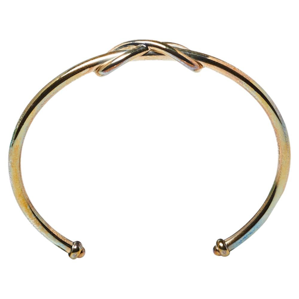 Define your delicate wrist by wearing this open cuff bracelet from Tiffany & Co. This silver band is simply fashioned with the infinity design at the center of the smooth band. This lovely piece can be accessorized with a formal or casual