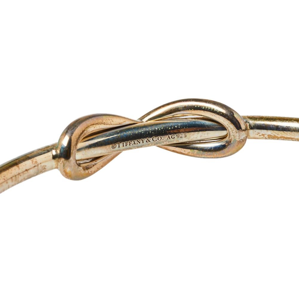 Define your delicate wrist by wearing this open cuff bracelet from Tiffany & Co. This silver band is simply fashioned with the infinity design at the center of the smooth band. This lovely piece can be accessorized with a formal or casual