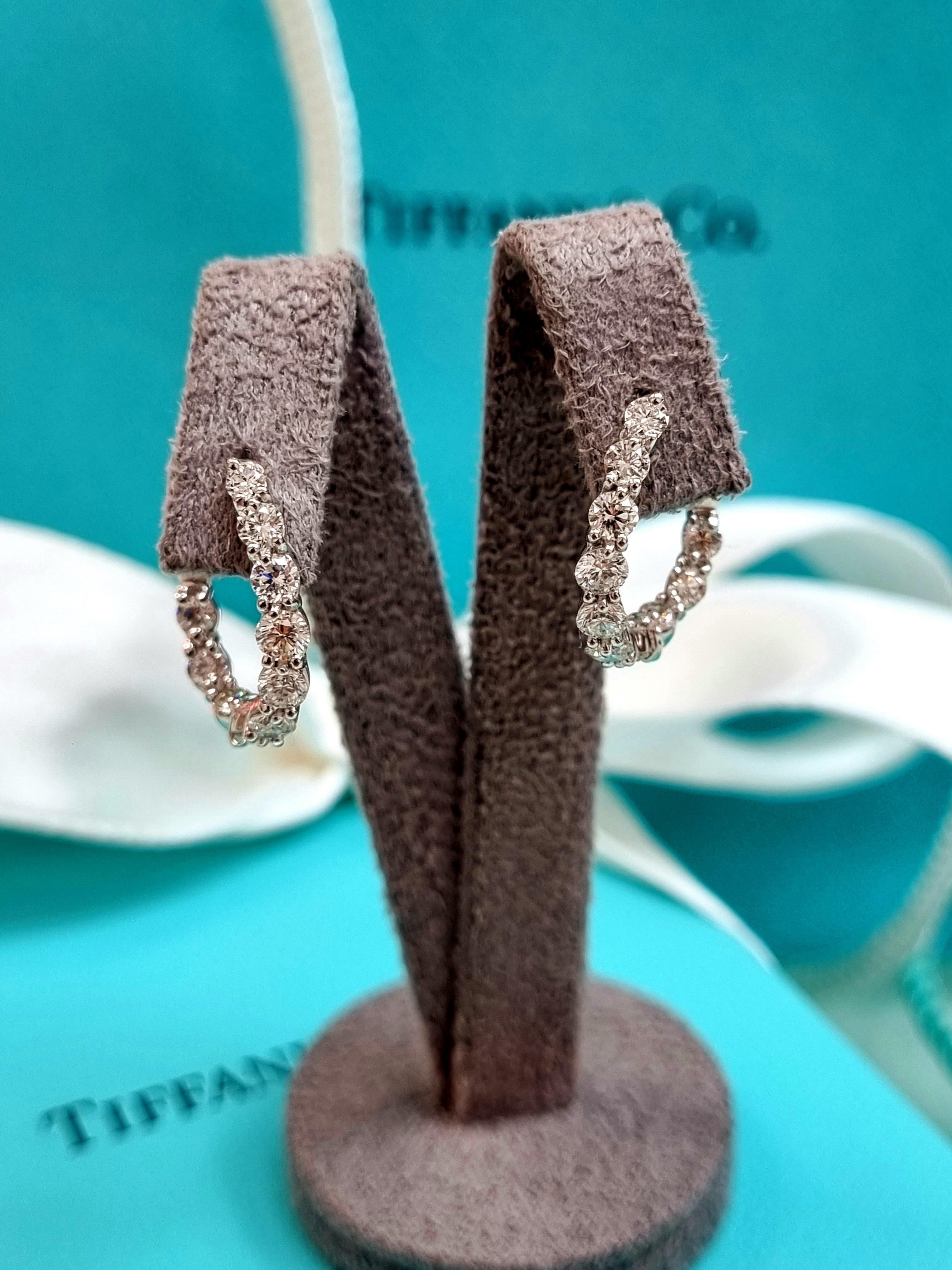 Introducing a luxurious pair of Tiffany & Co. Inside-Out Hoop Earrings, meticulously crafted in exquisite platinum, the epitome of timeless elegance and sophistication. These hoops redefine grace with a seamless blend of classic design and