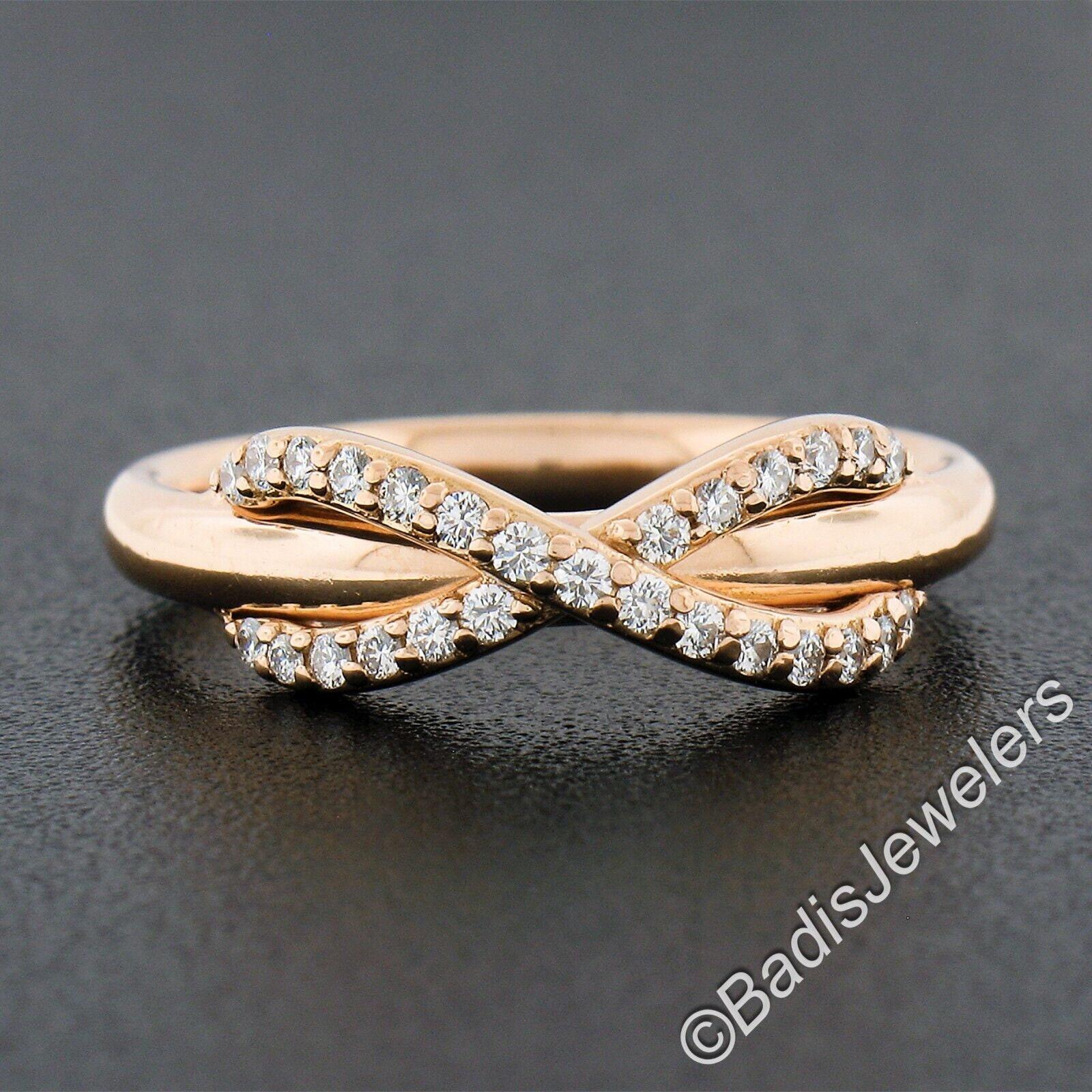 Here we have a Tiffany & Co. band ring crafted from solid 18k rose gold. This gorgeous band has a lovely infinity style design at its top that is perfectly lined with super fine quality diamonds pave set throughout. These fiery diamonds are round