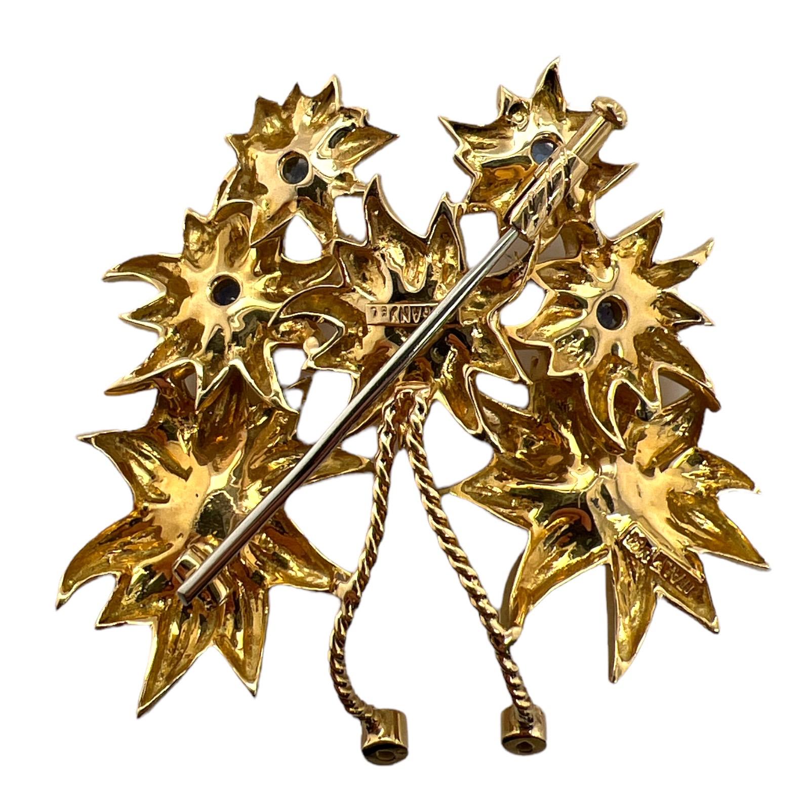 Beautifully crafted sapphire and pearl brooch by Tiffany & Co. Italy. The brooch is handcrafted in 18 karat yellow gold and features a bouquet of flowers featuring natural blue sapphires and cultured pearls. The pin measures approximately 2.00 x