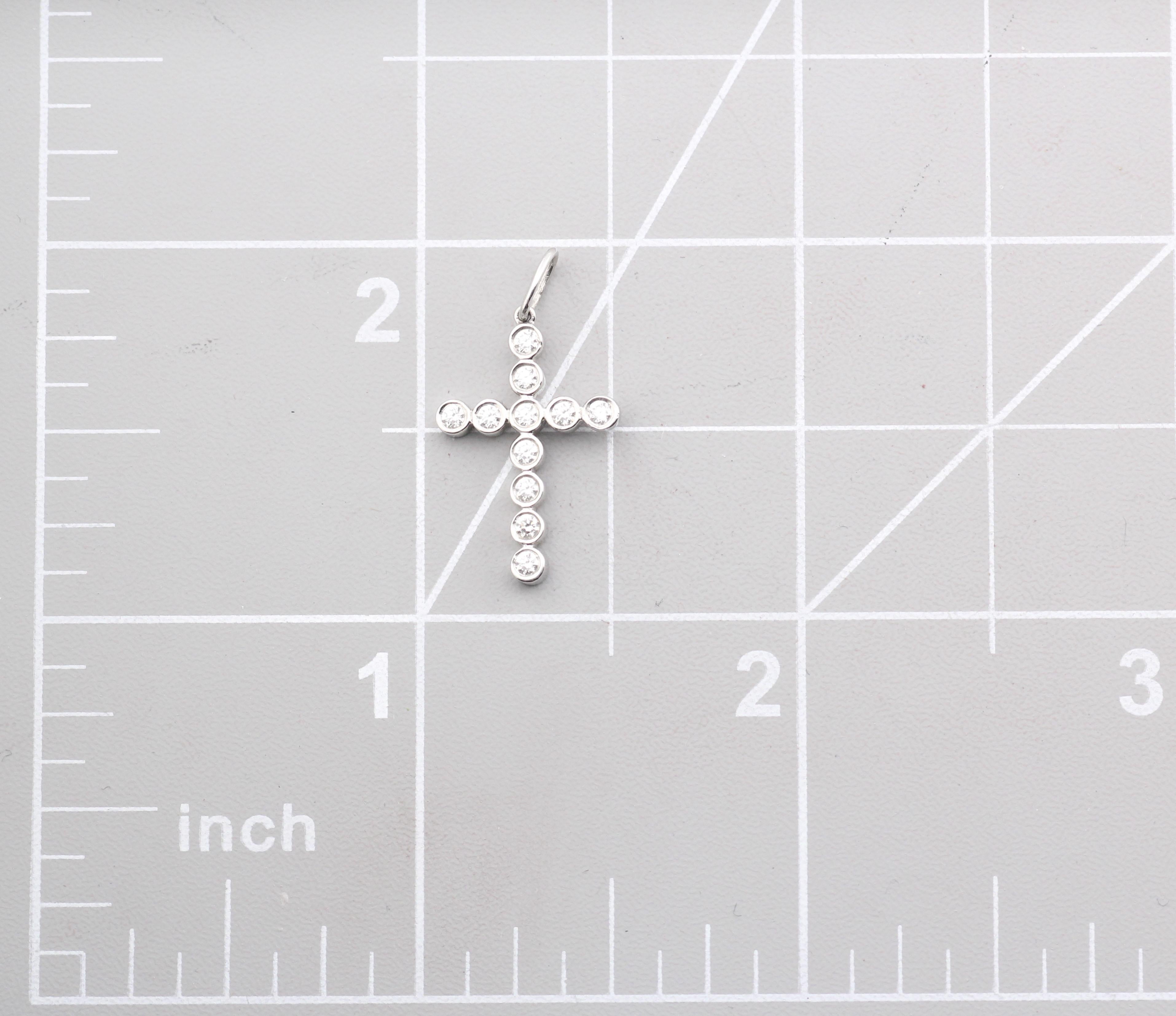 Die Tiffany & Co. Der Jazz Bezel Set Diamond Platinum Cross Pendant Charm ist ein bezauberndes und anmutiges Schmuckstück, das die Hingabe der Marke für exquisite Handwerkskunst und zeitloses Design unter Beweis stellt. Diese Anhänger-Halskette ist