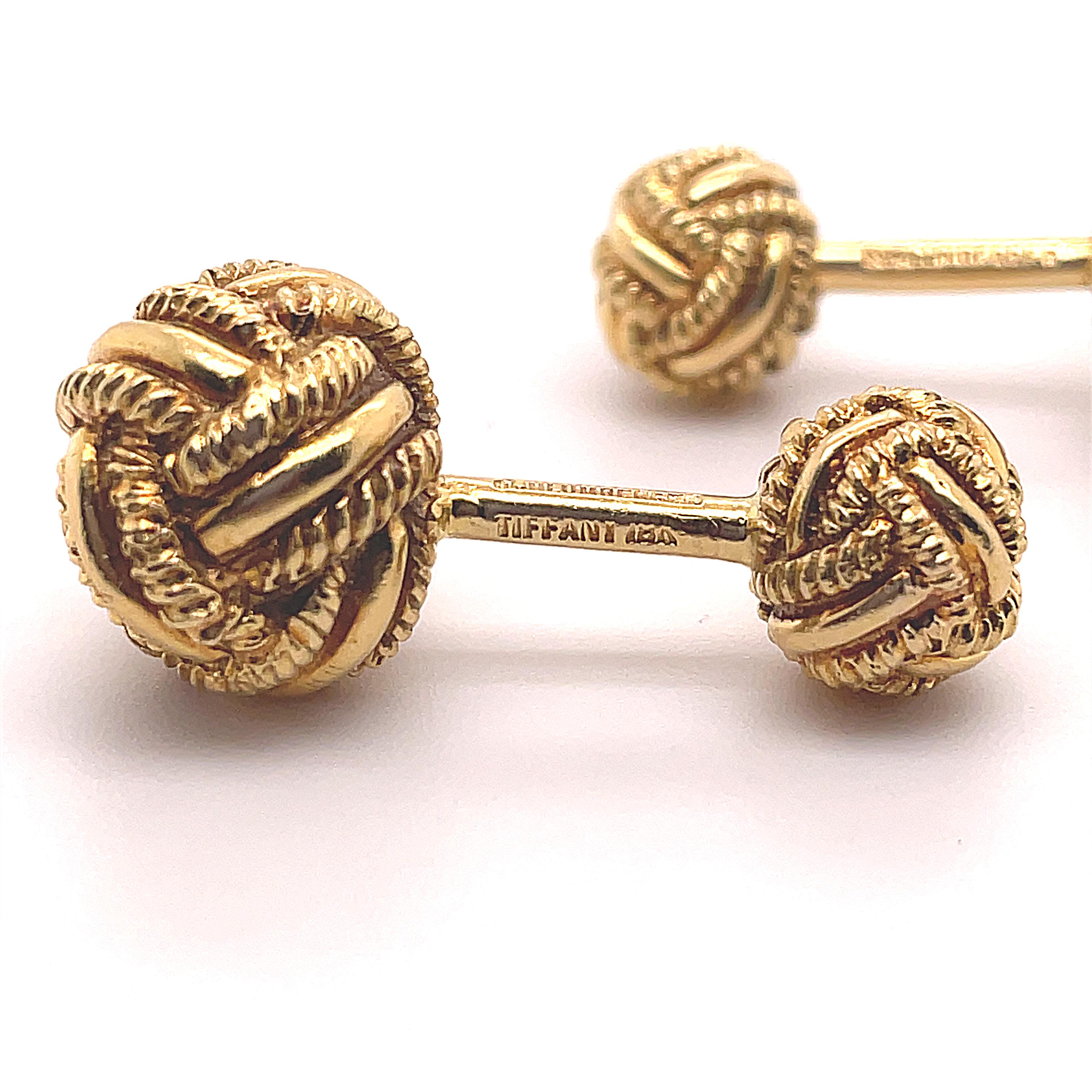 A pair of Tiffany & Co. Jean Schlumberger 18 karat yellow gold knotted cufflinks, circa 1960.

These smart vintage cufflinks feature two vari-sized intricately detailed knots between T-bar fittings.

The solid and secure yellow gold T-bar fitting