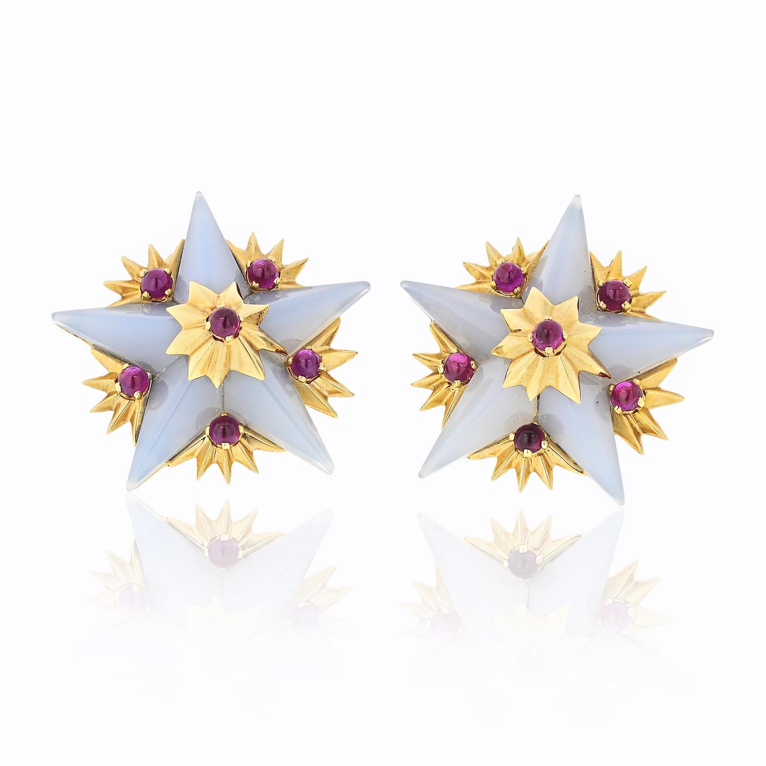 A Pair of Tiffany & Co Schlumberger Gold, Chalcedony and Ruby Earrings. Designed as chalcedony stars with multiple 18K yellow gold bursts featuring round cabochon rubies; earring backs are clip-on; comes with a suede Tiffany box; each earring