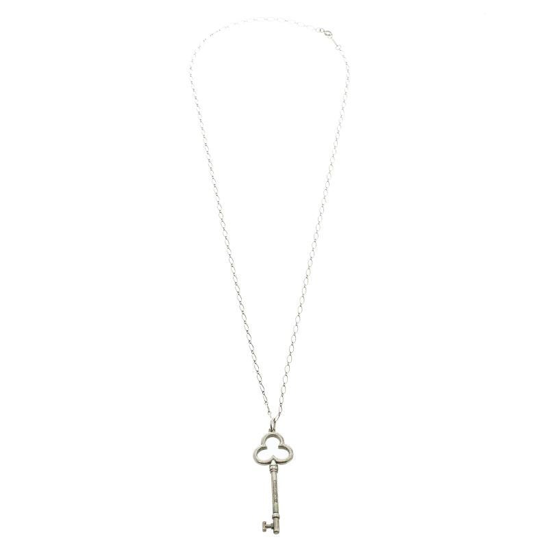 This timeless necklace from the house of Tiffany & Co. is cast in silver 925 and features a key motif. It comes with the Tiffany & Co. lettering engraved on it and is held by a chain which comes secured with spring ring closure. Wear with a blouse