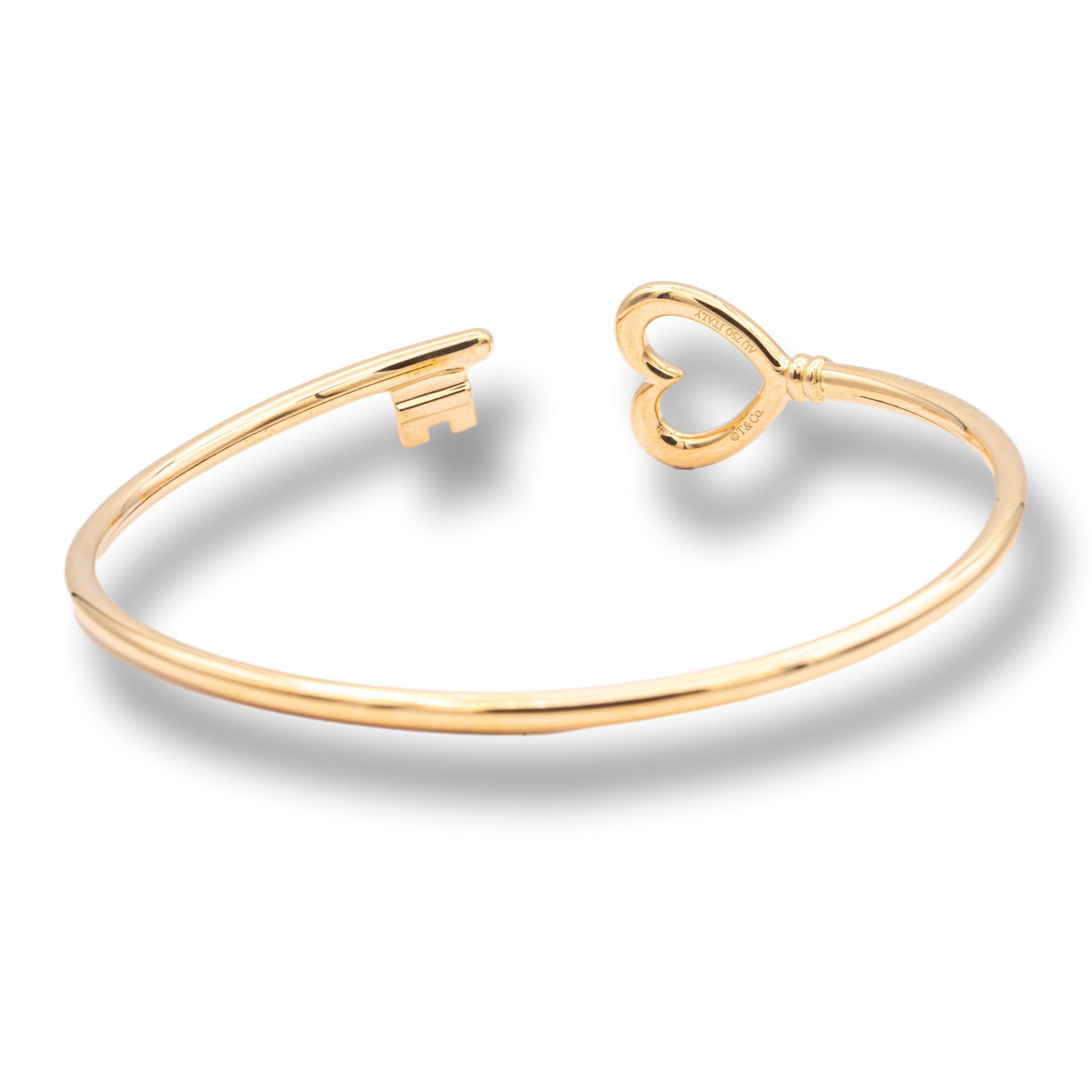 Tiffany & Co. Keys Wire heart bangle bracelet finely crafted in 18 karat rose gold with an open heart and key design. Fits wrist of 6.75