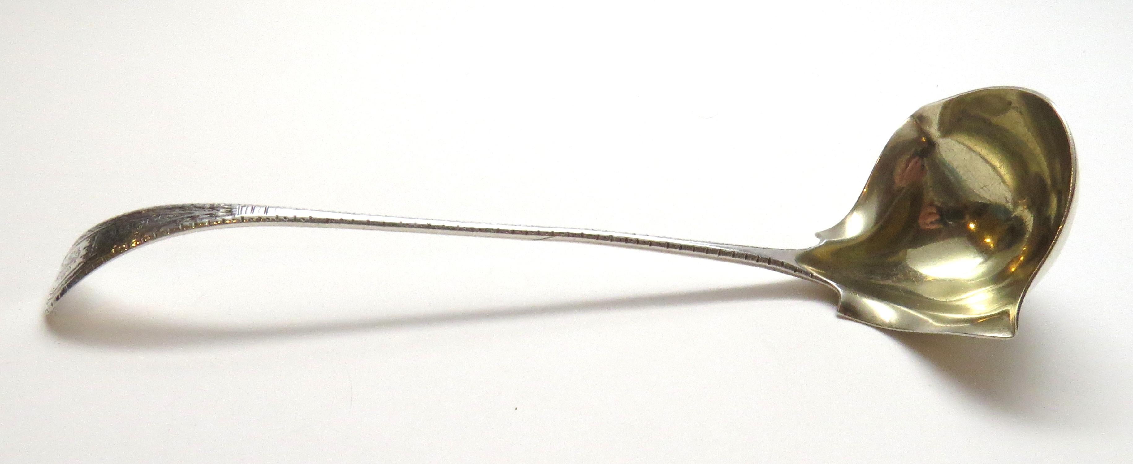 Tiffany & Co. King William engraved sterling silver double-lipped cream ladle. 
This is a lovely King William engraved sterling silver and gold washed double lipped cream ladle designed by Tiffany & Co. Measurement: Approximate 9 1/4 inches in