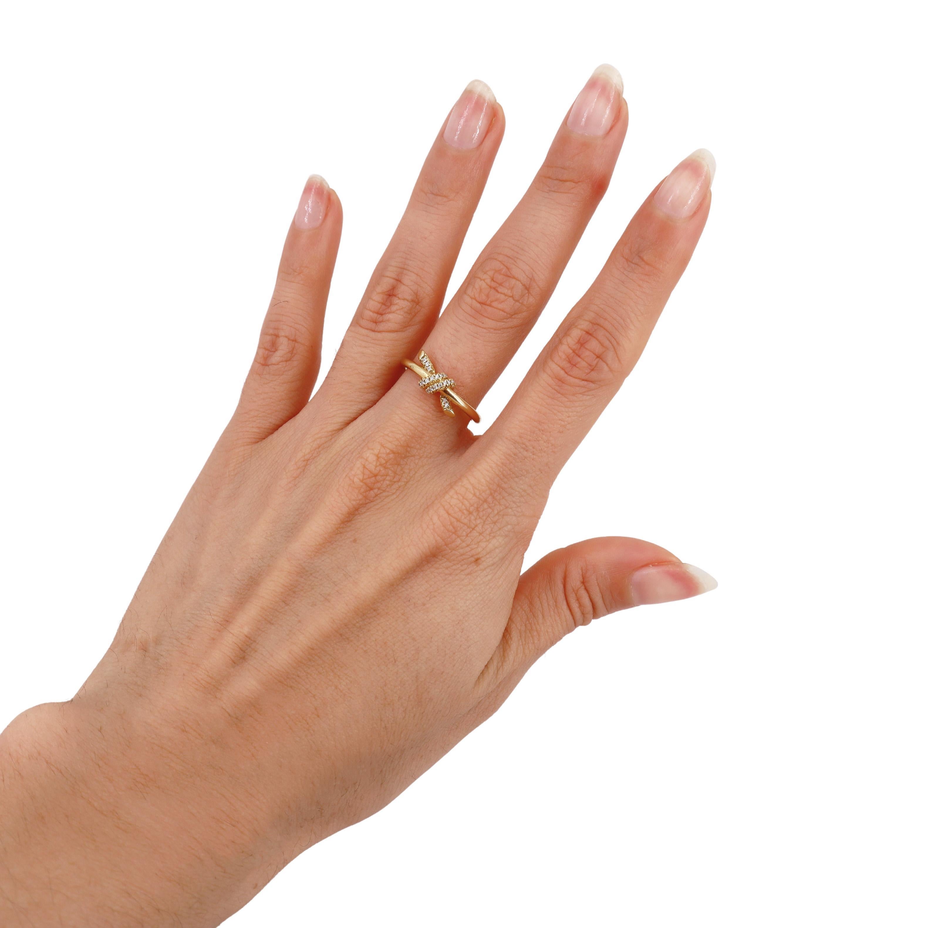 Introducing the iconic Knot ring from Tiffany & Co., expertly crafted in 18kt yellow gold. This elegant piece is accented with 27 round cut diamonds that weigh approximately 0.05 carats, showcasing a stunning F-G color and VS1 clarity.

Inspired by